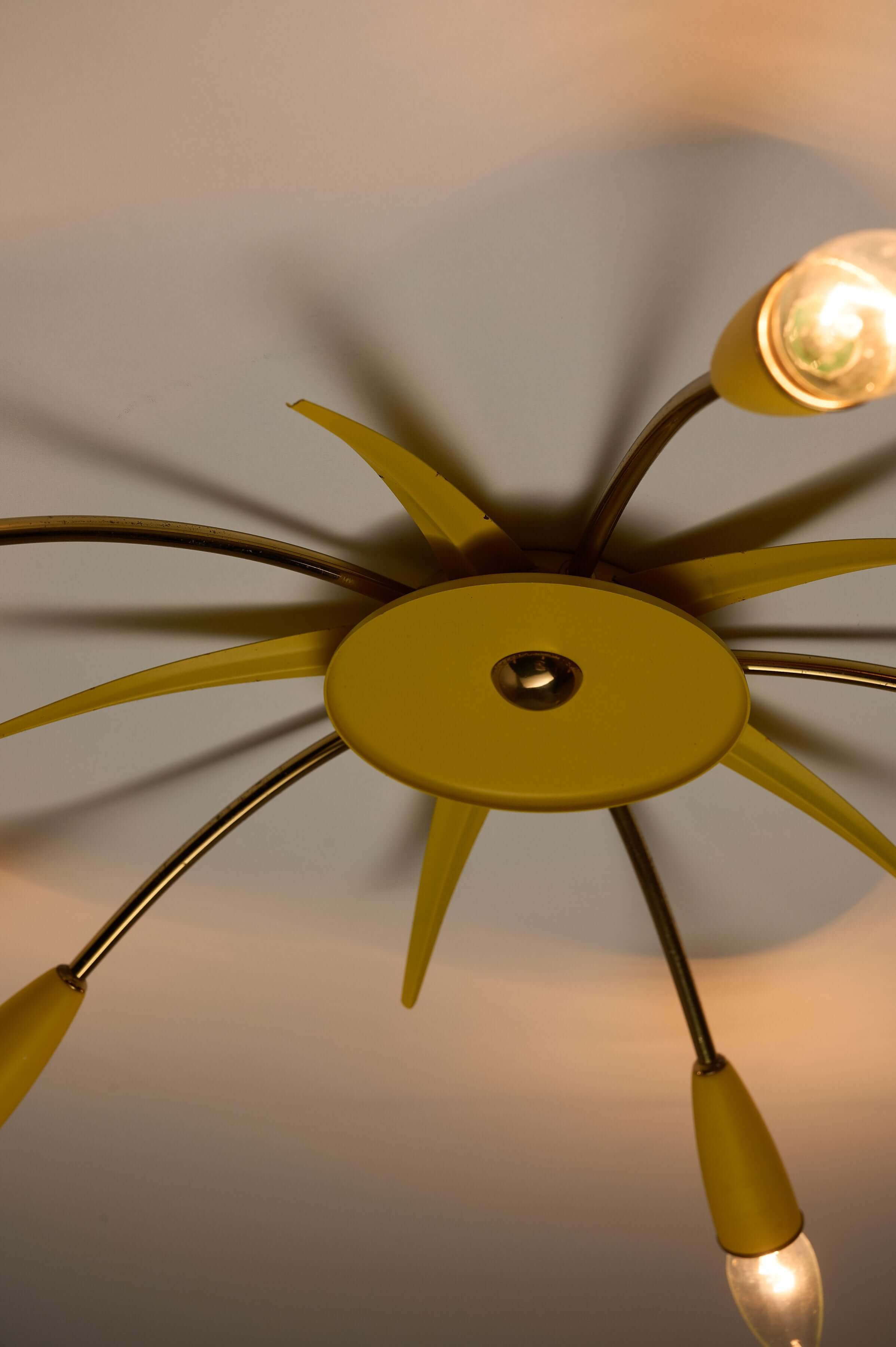 Mid-Century Yellow Sputnik Ceiling Lamp from below, featuring five brass arms and yellow lacquered hub with cone sockets.