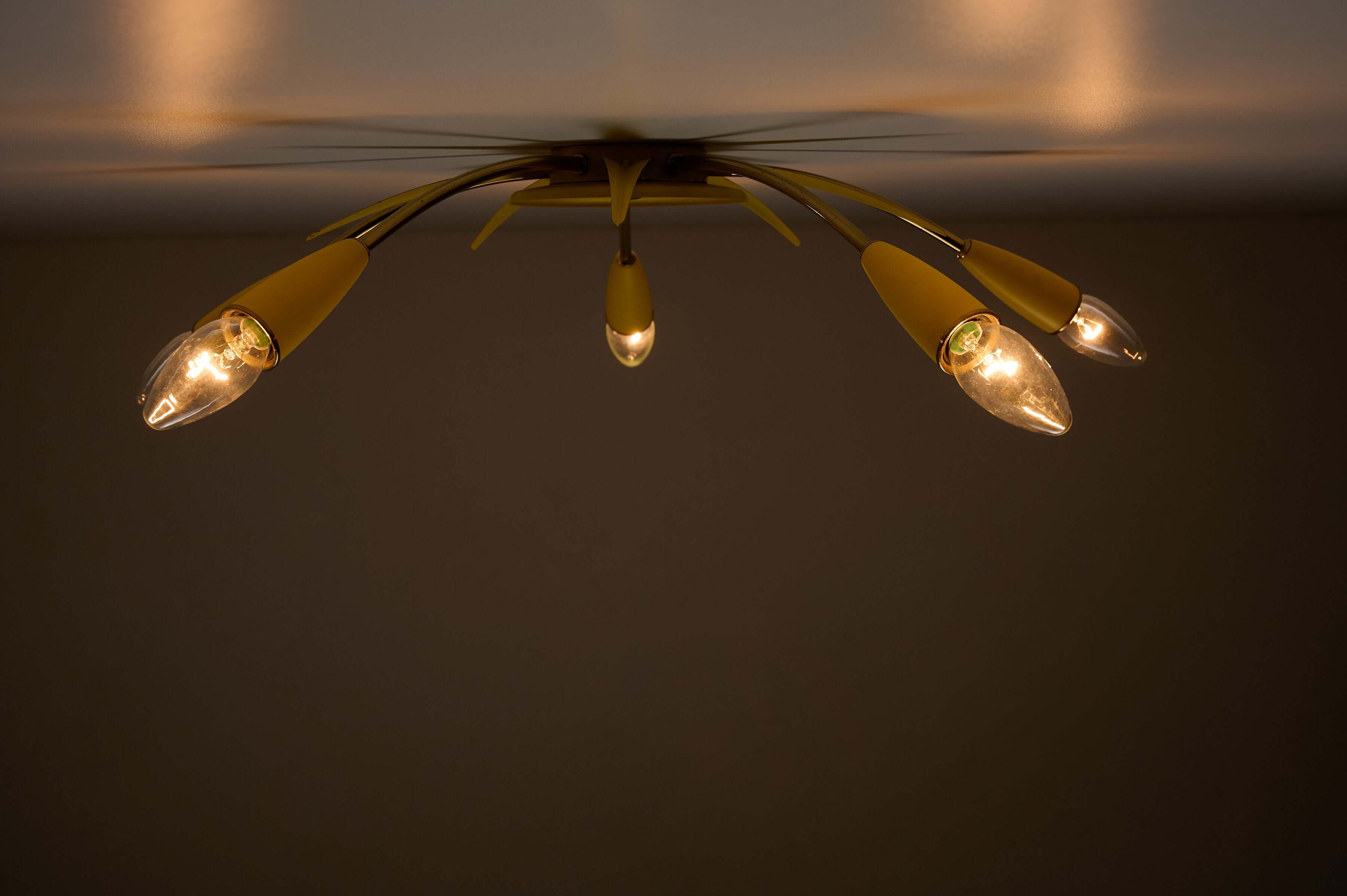 Mid-Century Yellow Sputnik Ceiling Lamp featuring five brass arms and yellow metal cone sockets.