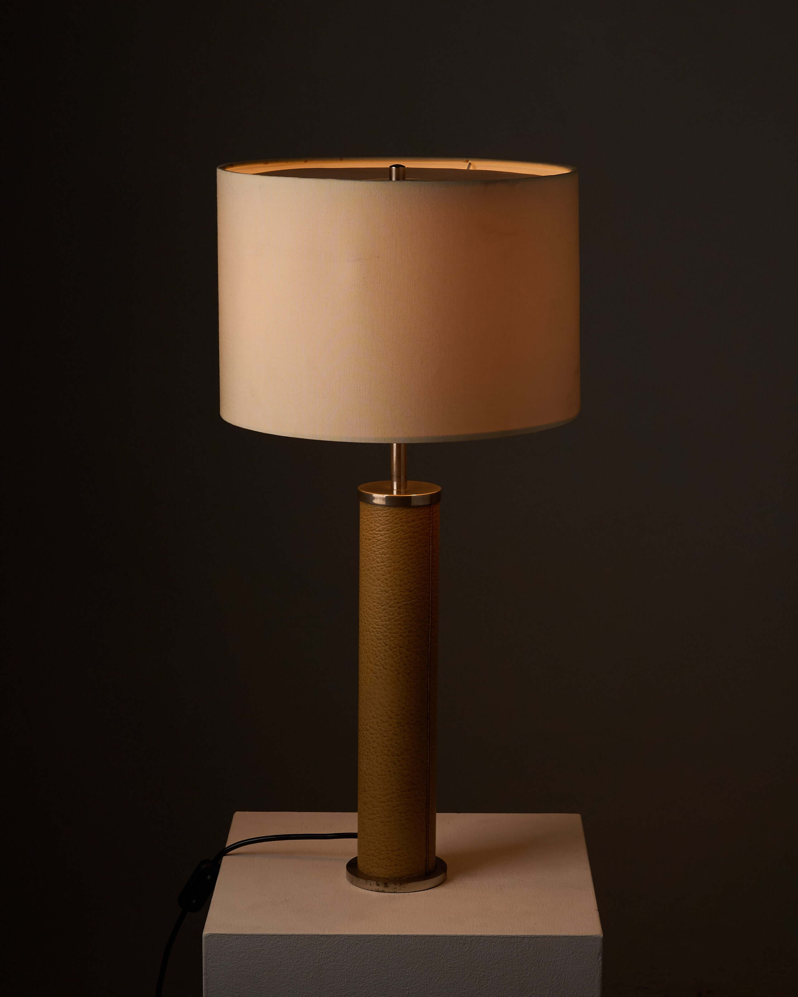Cylinder Table Lamp in Stitched Natural Leather showcasing textured leather base and cream fabric shade.