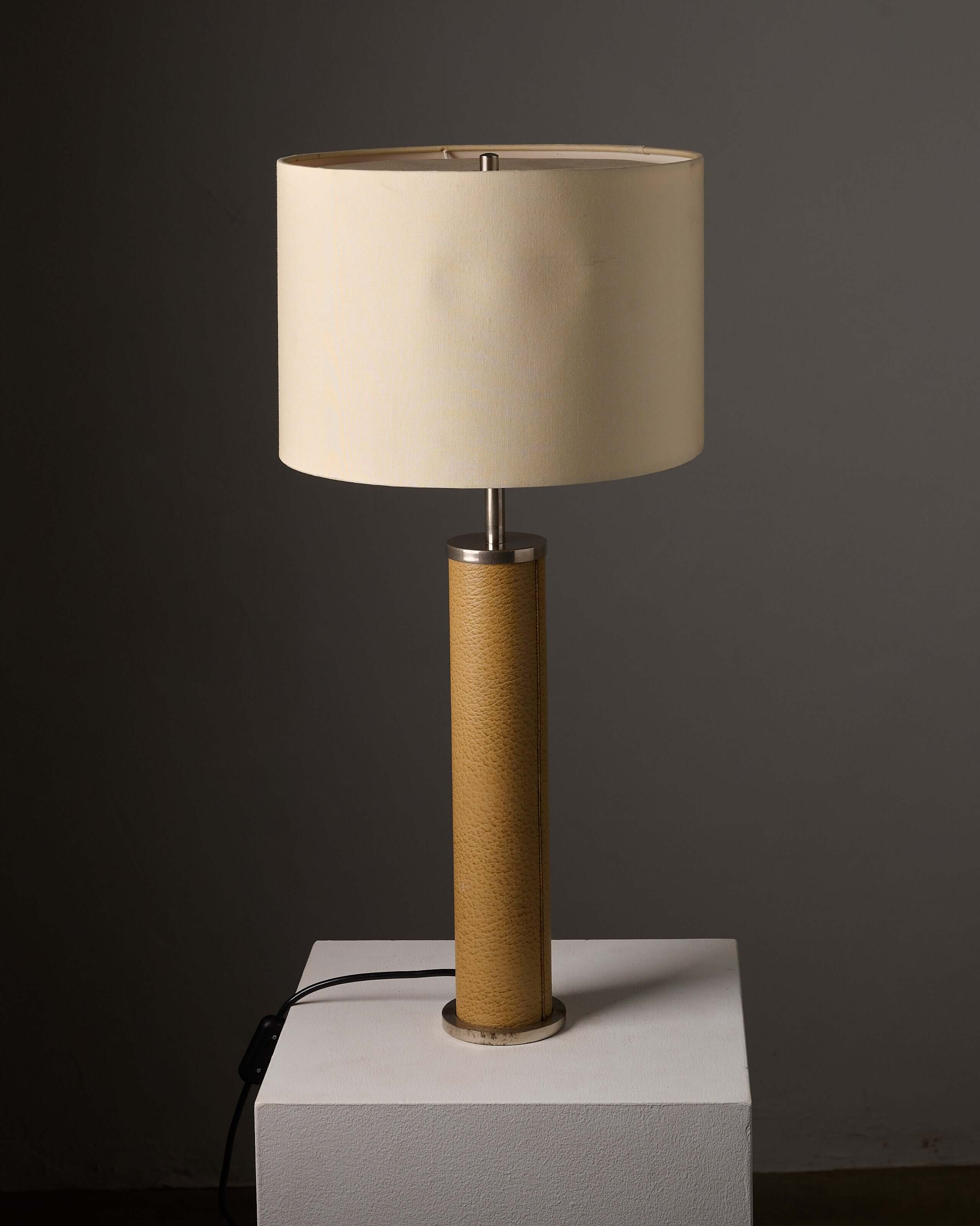Cylinder Table Lamp in Stitched Natural Leather with tan leather base and cream fabric shade.