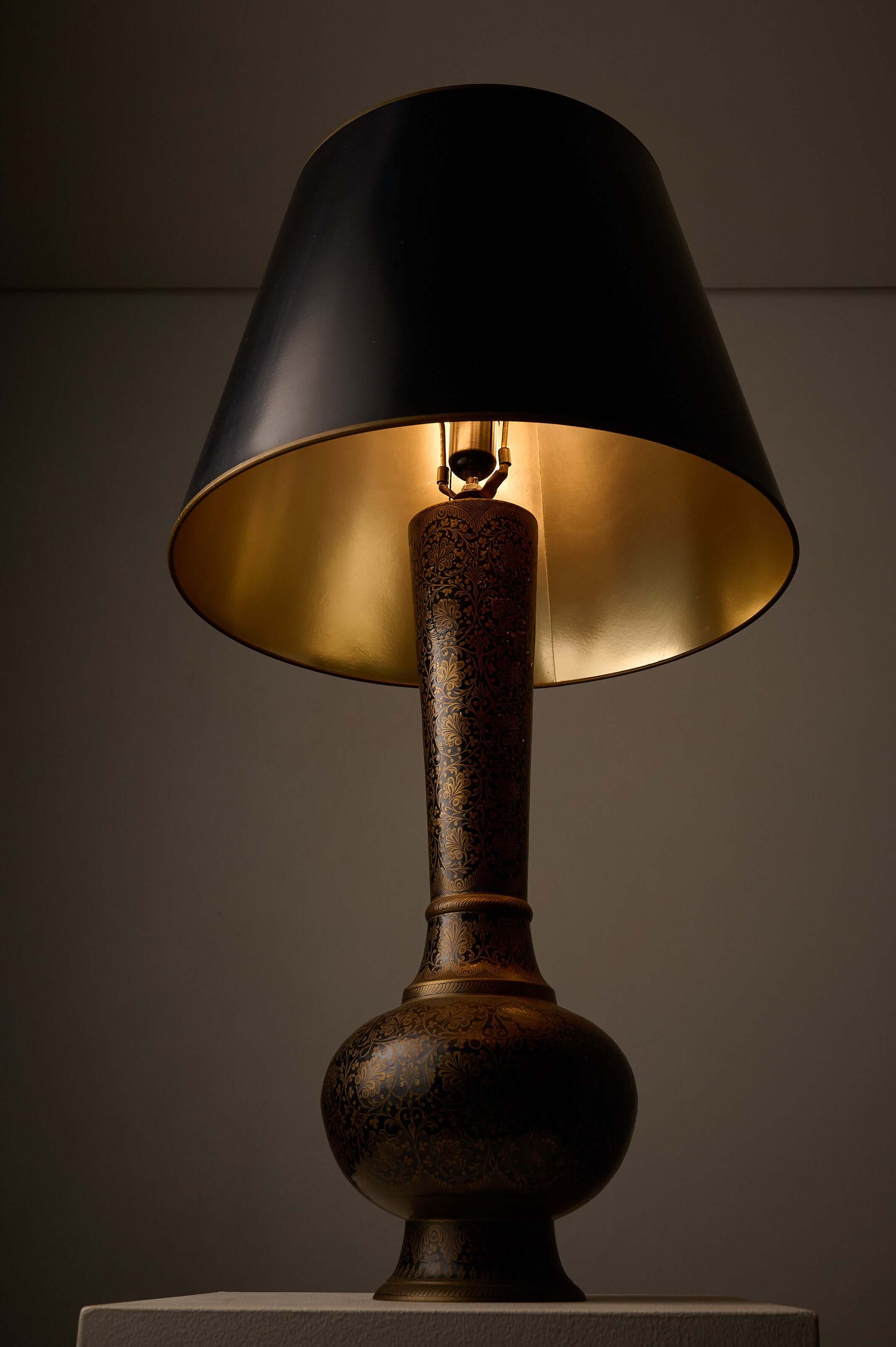 Tall Black and Gold Vase Lamp with Foliage Pattern, featuring a bottle-shaped base and a black conical shade.