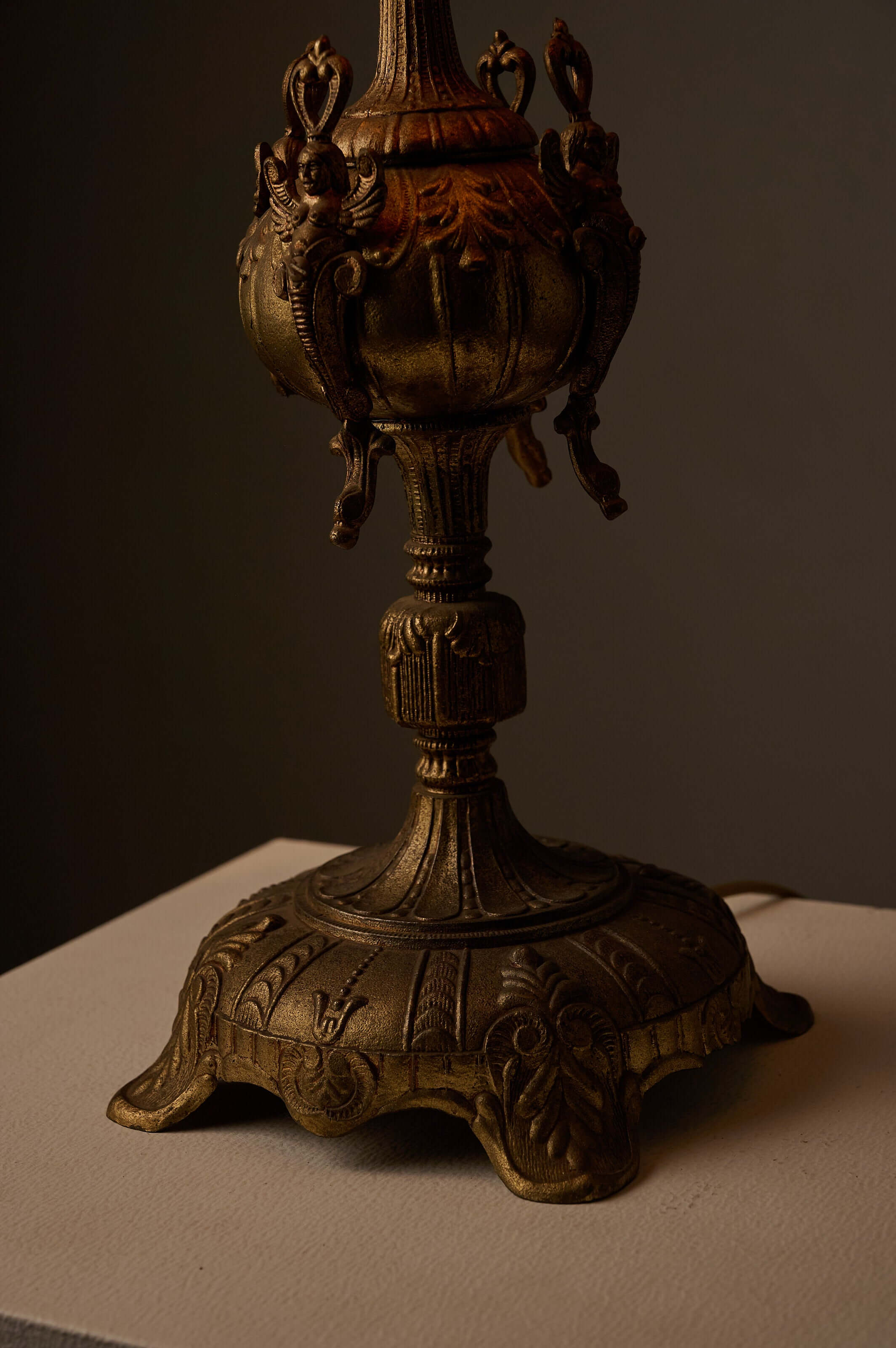 Cast Brass Table Lamp with Stitched Parchment Shade featuring a detailed cast metal base with winged figures.