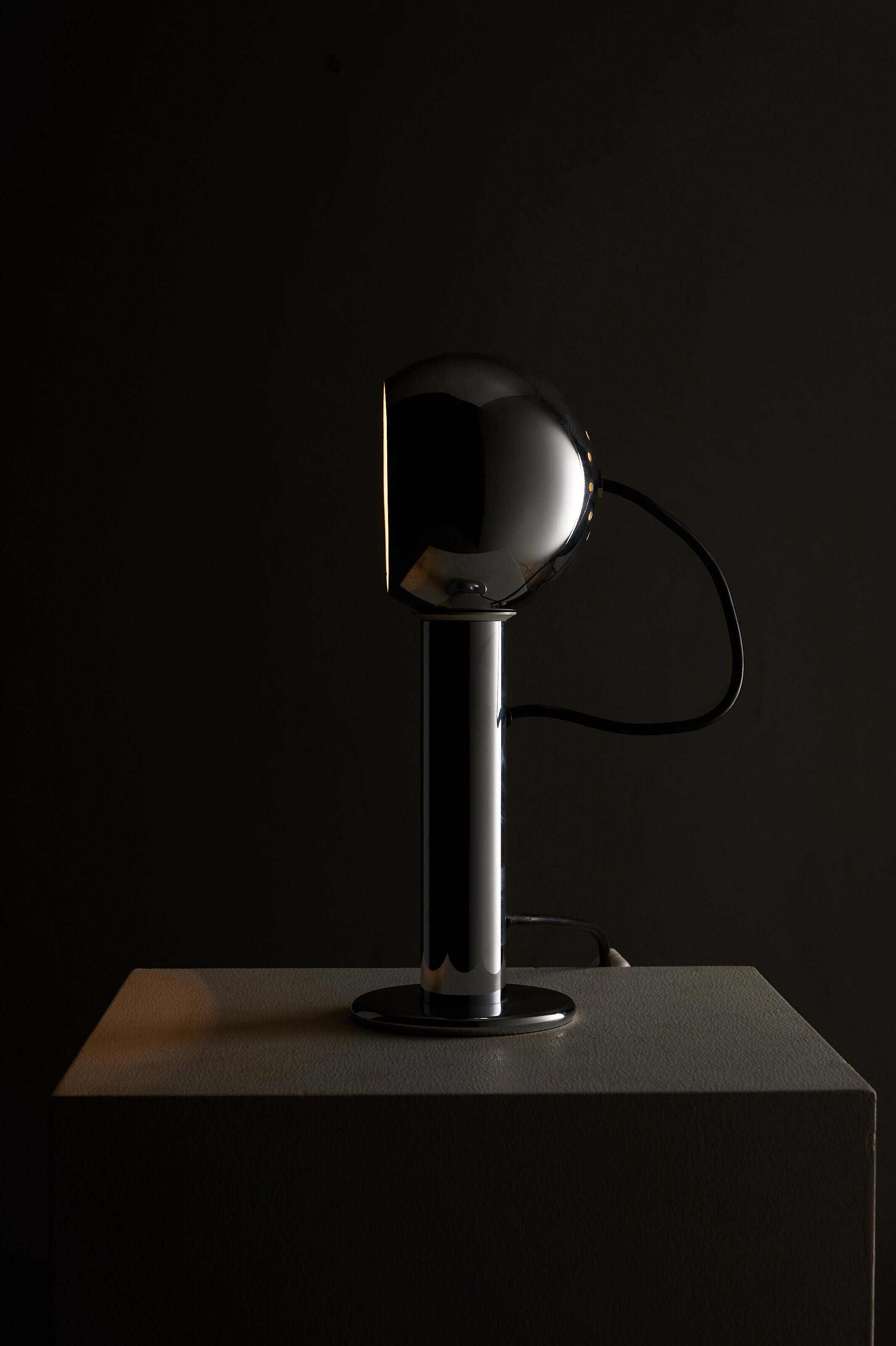 Adjustable chrome table lamp featuring a polished chrome spherical shade on a cylindrical base.