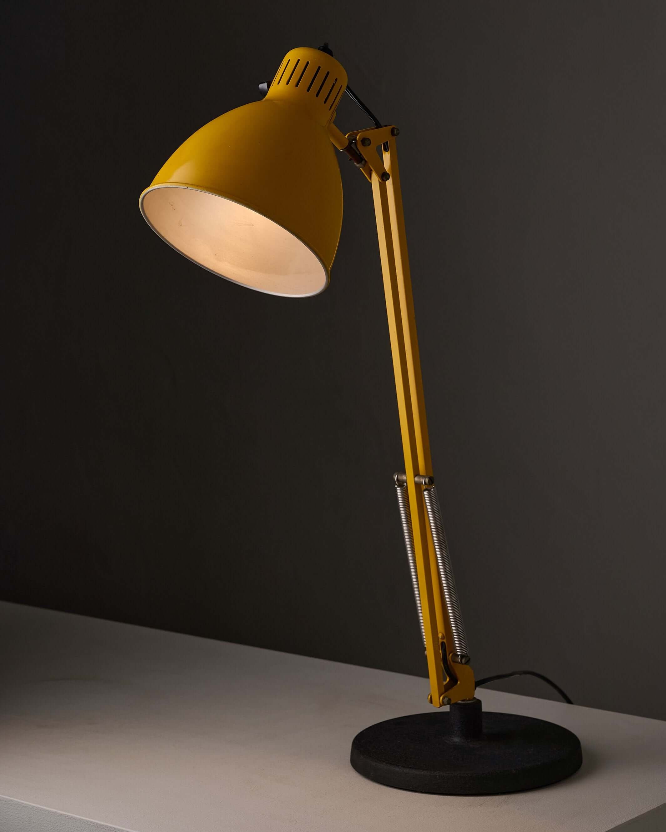 Yellow adjustable architect desk lamp with balanced-arm design and cast iron base, ideal for precise positioning.