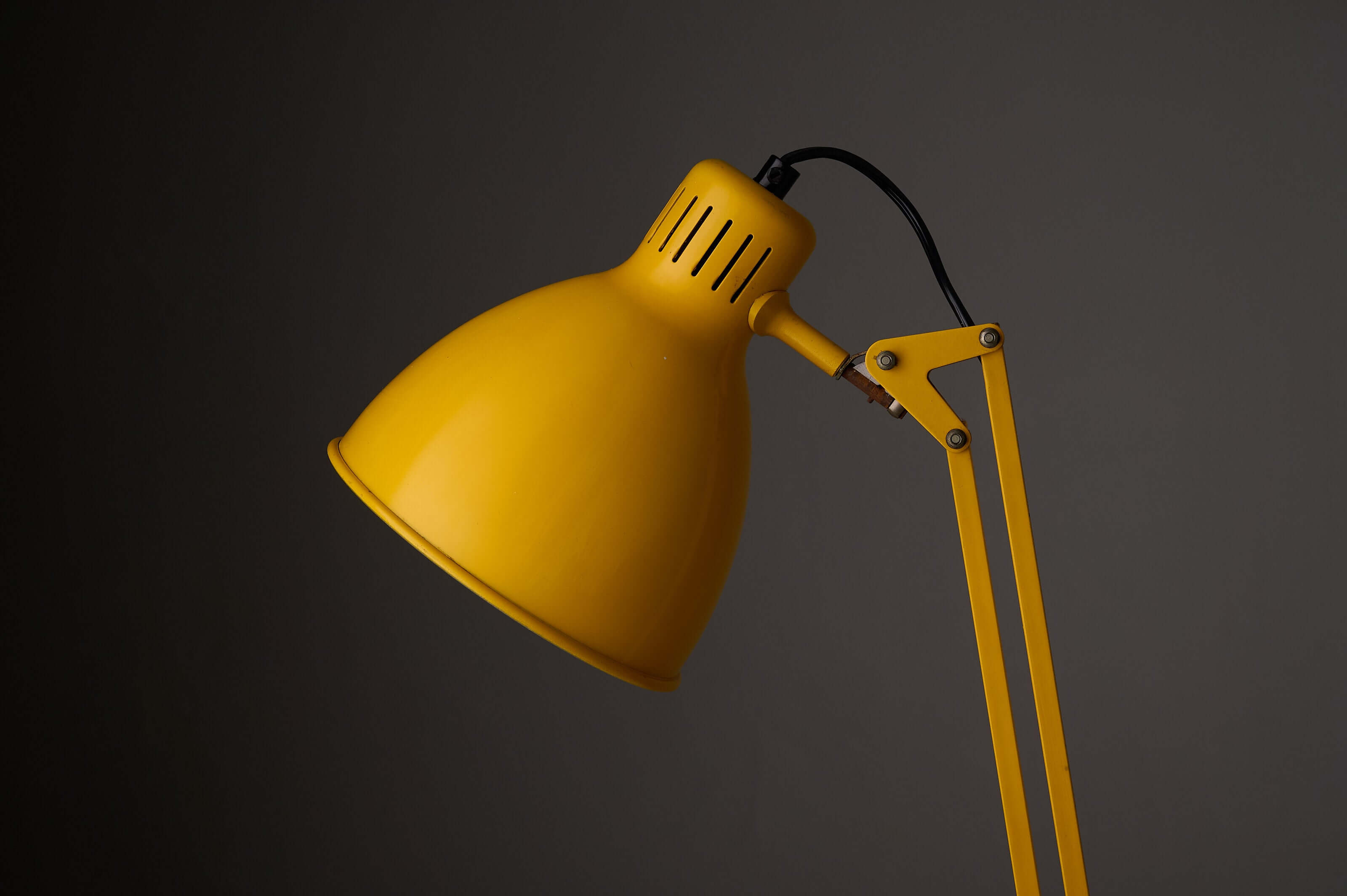 Yellow adjustable architect desk lamp with a modern design and adjustable arm feature.