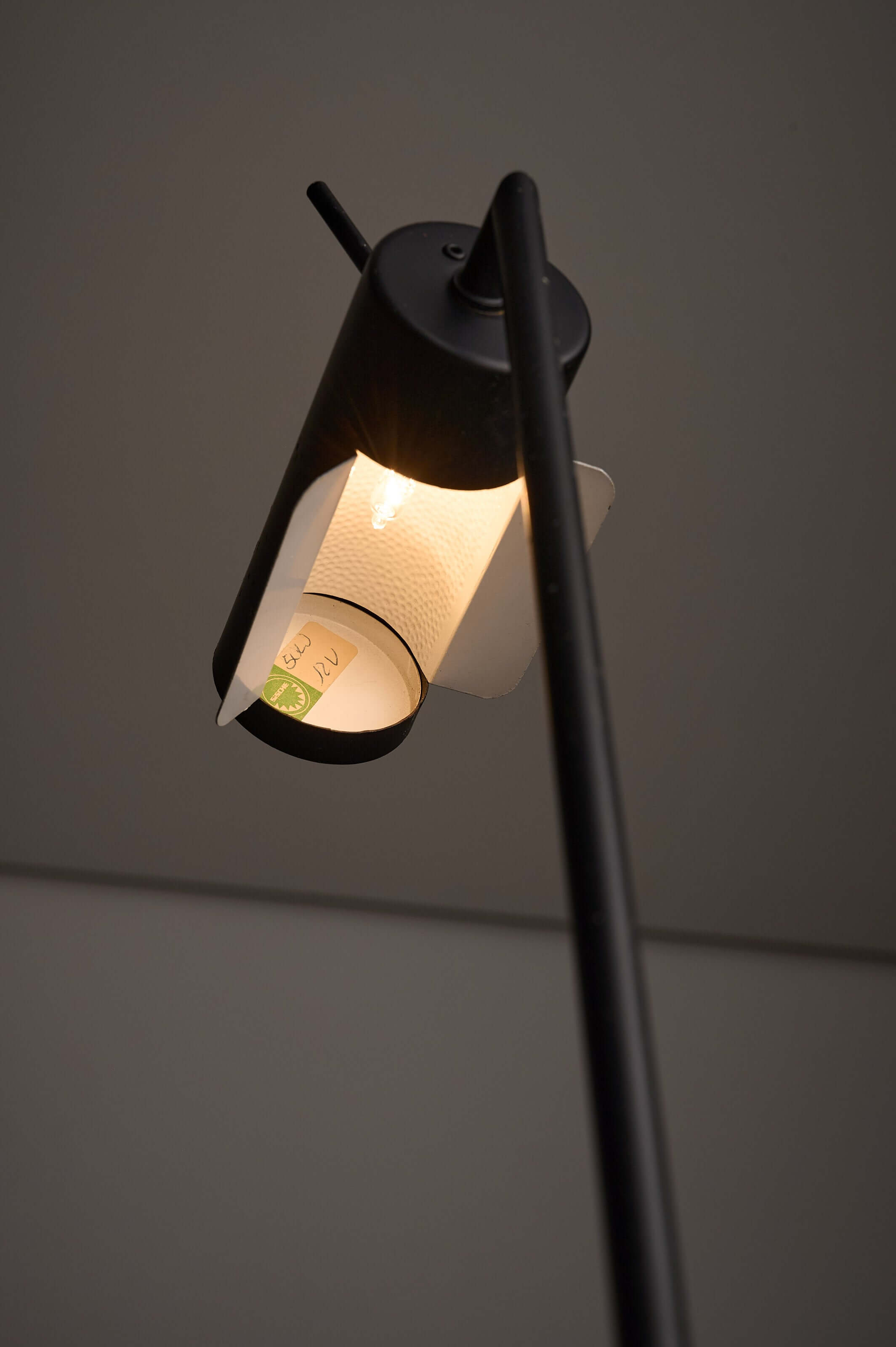 Matte Black Counterbalance Desk Lamp by Sische showcasing its adjustable cylindrical head and light features.