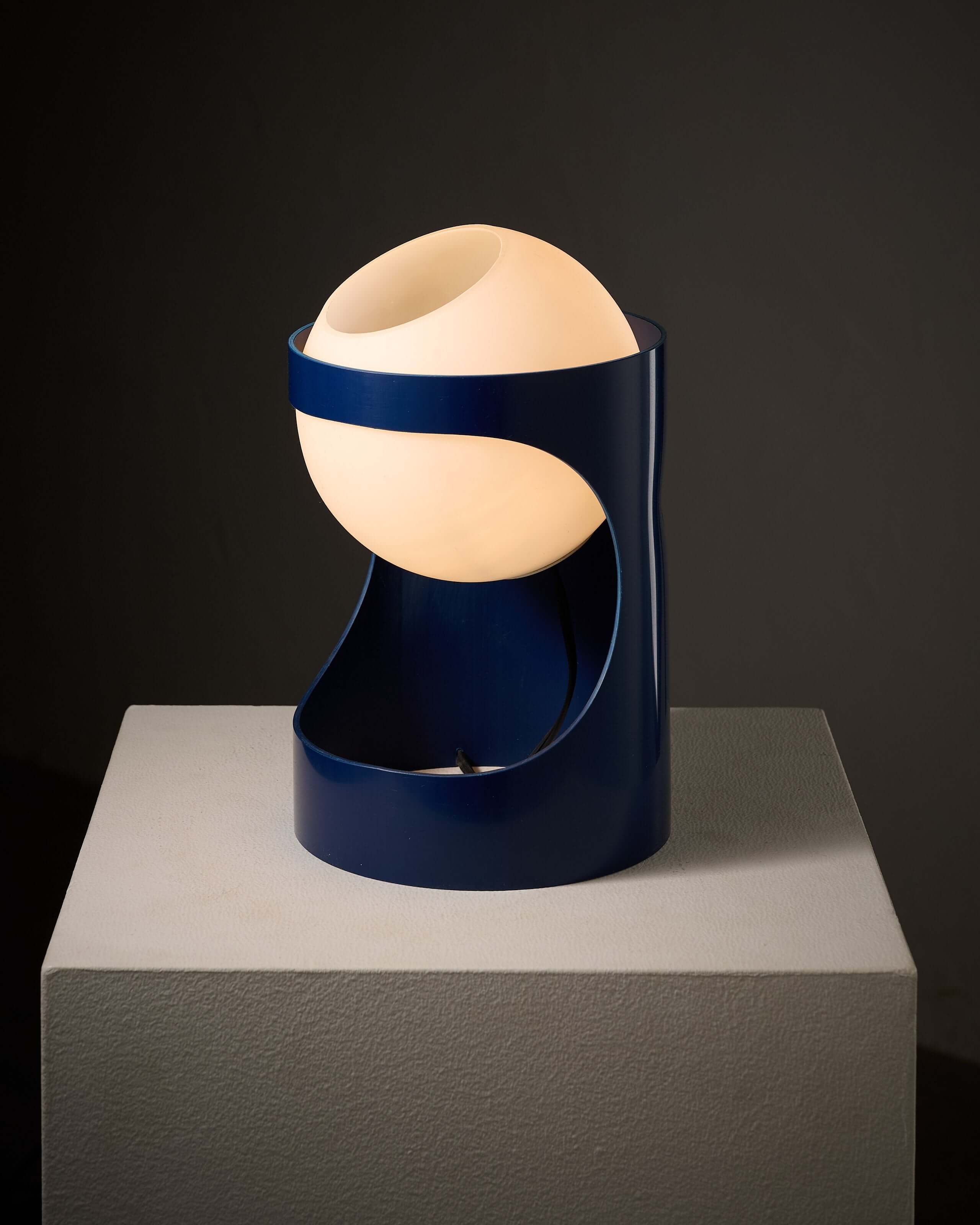 Blue 'L1' table lamp by Jacob Guggerli on display, showcasing its unique design and soft glow.