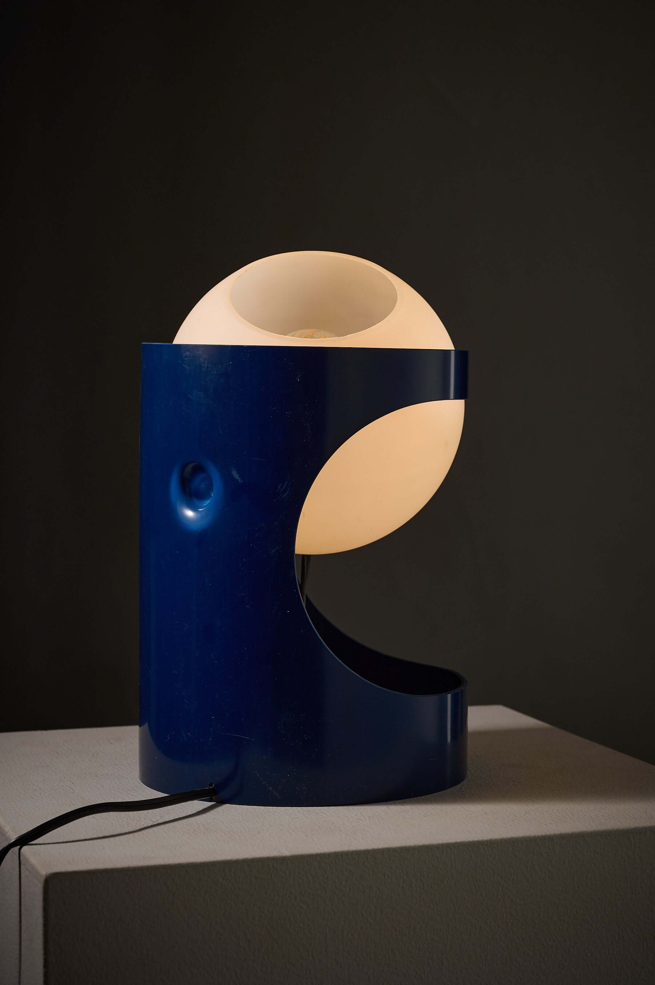 Blue 'L1' table lamp by Jacob Guggerli featuring a blue cylindrical shell and a loose opal glass sphere.