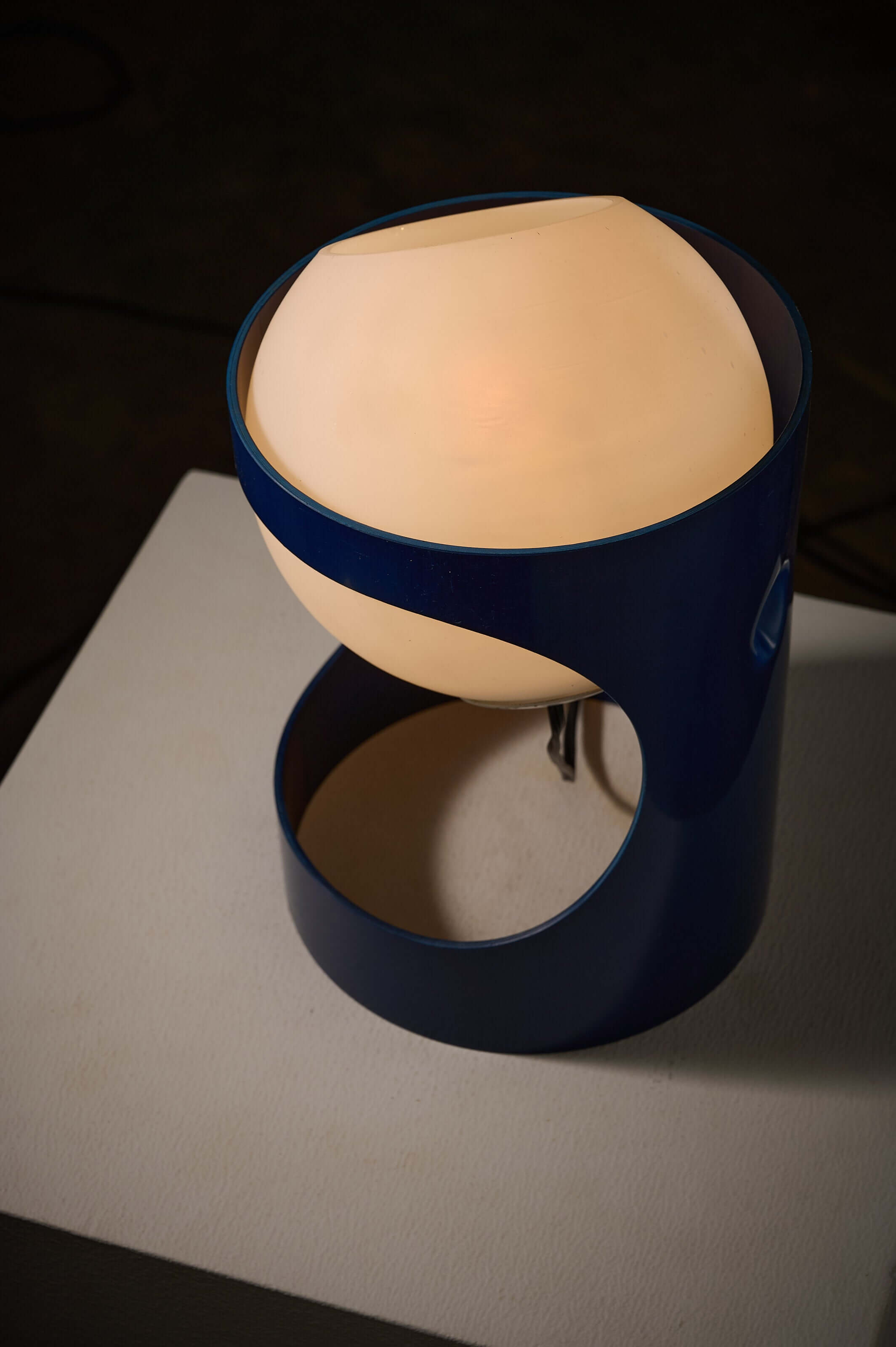 Blue 'L1' Table Lamp by Jacob Guggerli featuring a loose opal glass sphere and cylindrical blue plastic shell.
