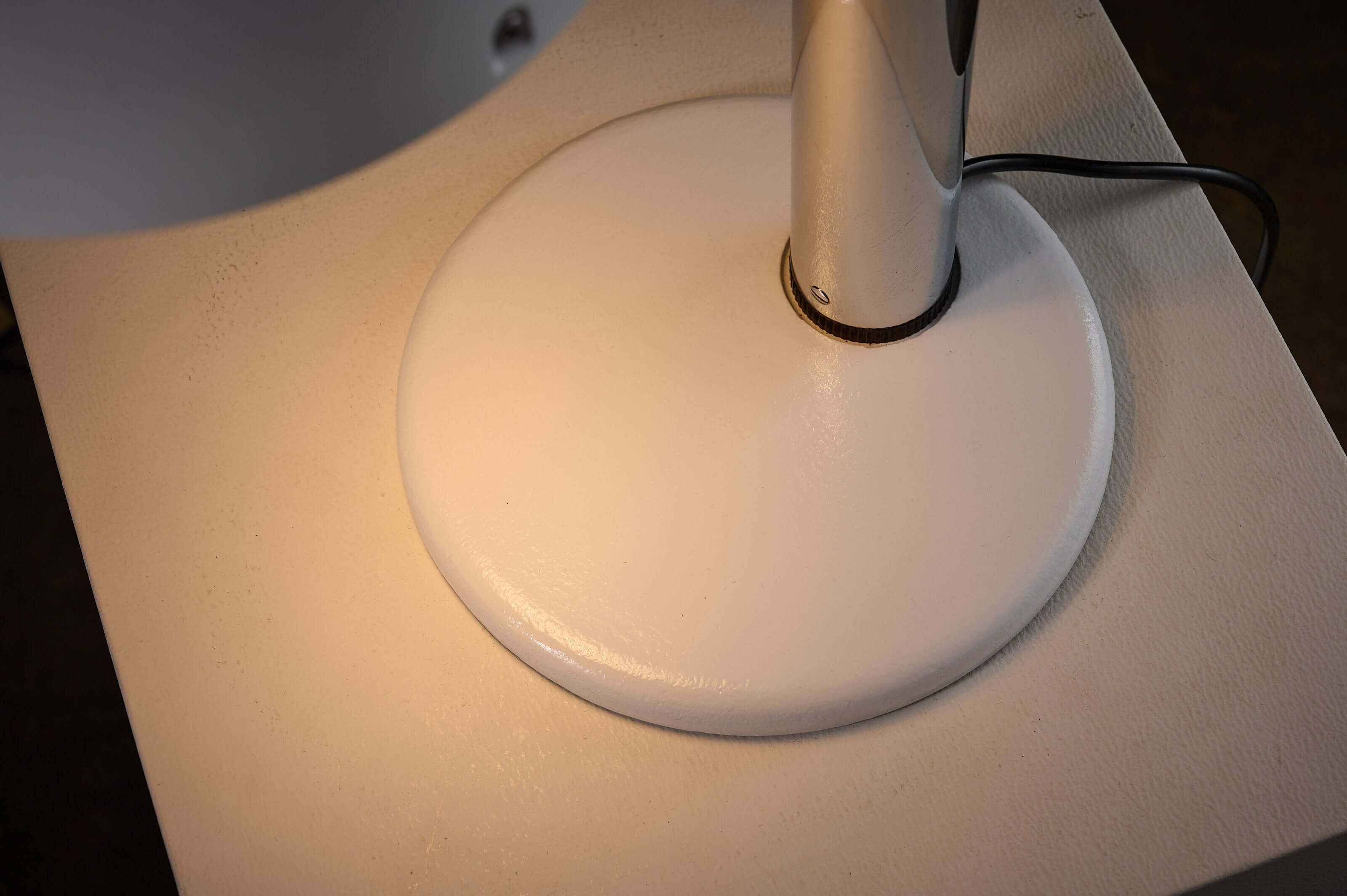 White base of chrome table lamp Enrique Franch, featuring texture and light reflection.