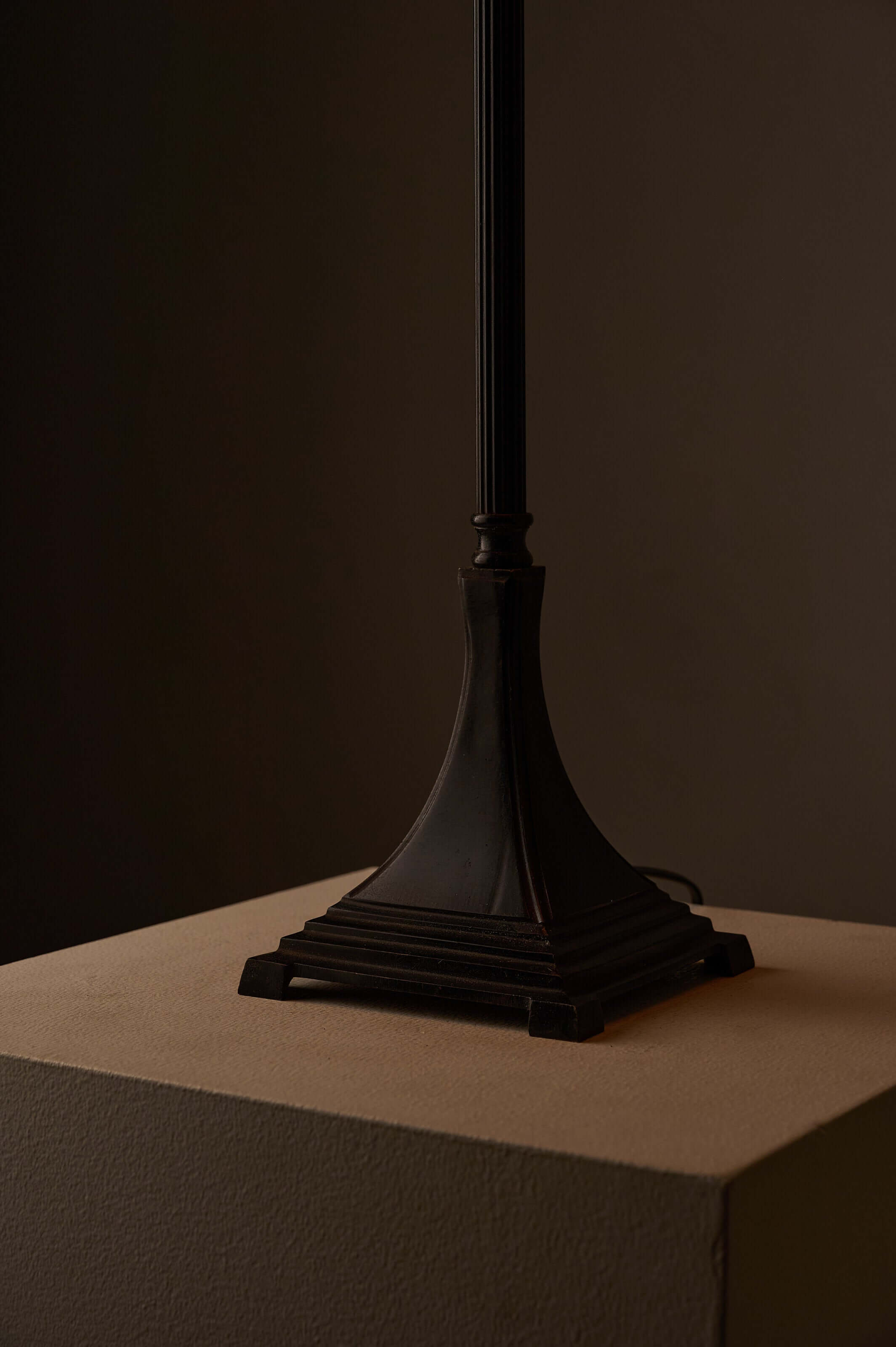 Neoclassical metal table lamp base featuring a solid square design and dark patinated finish.