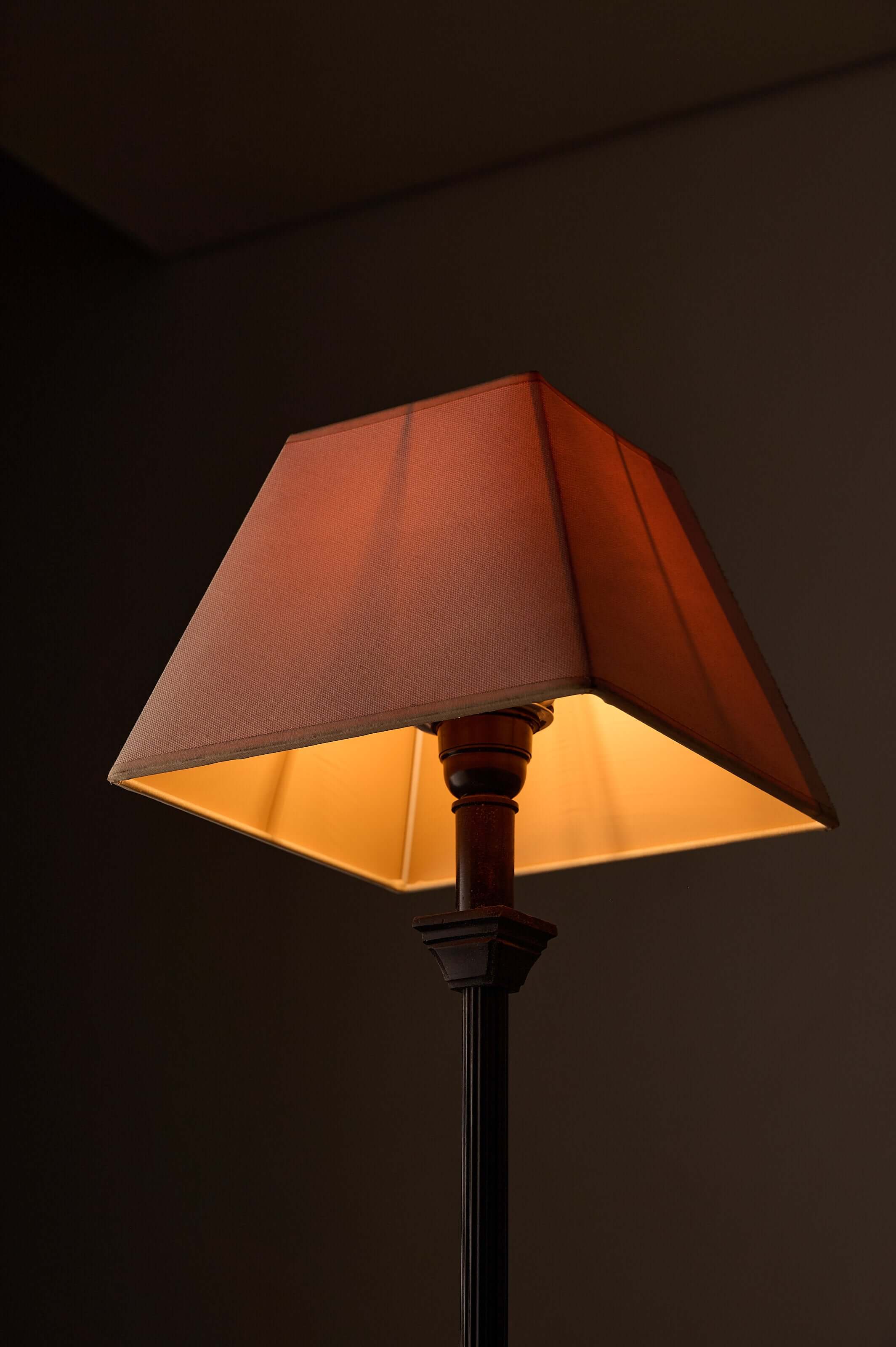 neoclassical metal table lamp with fabric shade, warm light illuminating the elegant design.