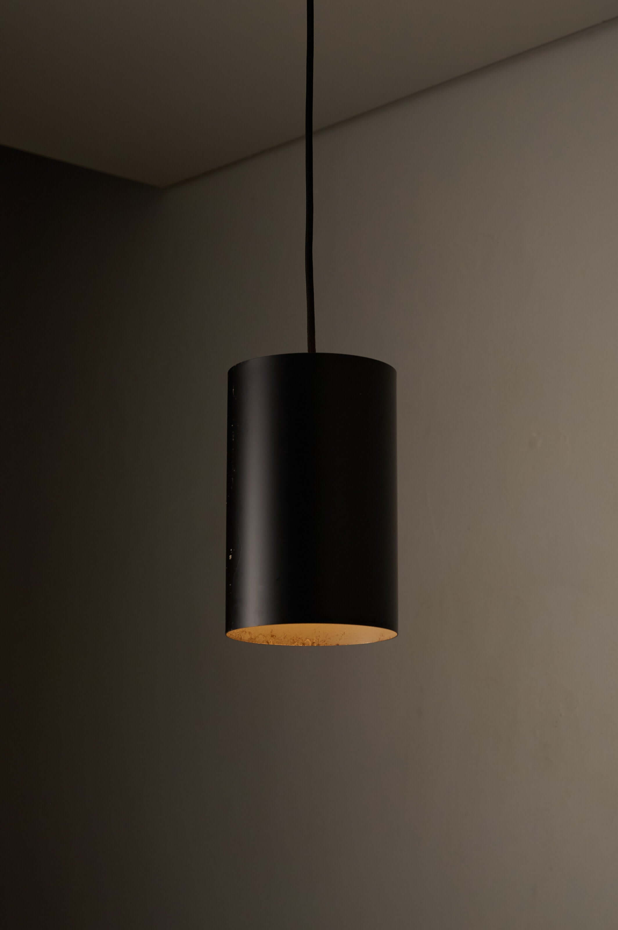 Minimalist Black Cylinder Pendant by Fog & Mørup, 1960s hanging against a neutral wall.