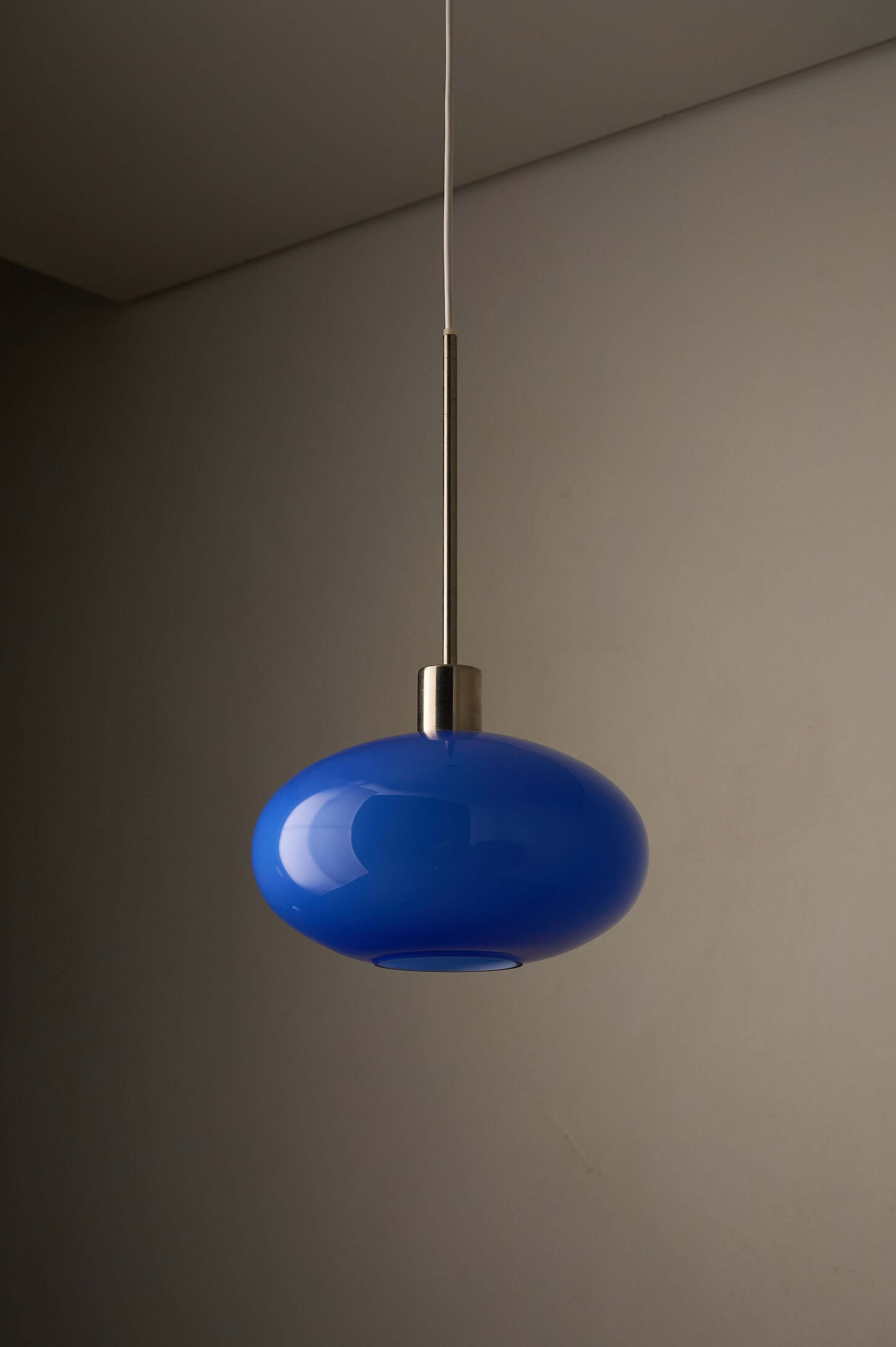 Azure Blue Opaline Glass Pendant with Metal Stem hanging from ceiling.