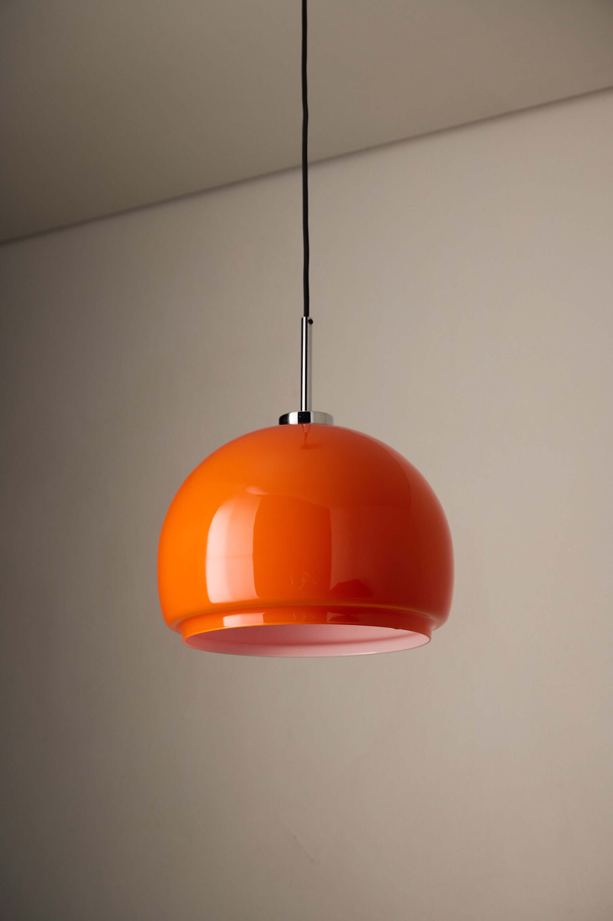 Orange Opaline Glass Pendant by Fog & Mørup suspended from the ceiling, showcasing its vibrant tangerine hue.