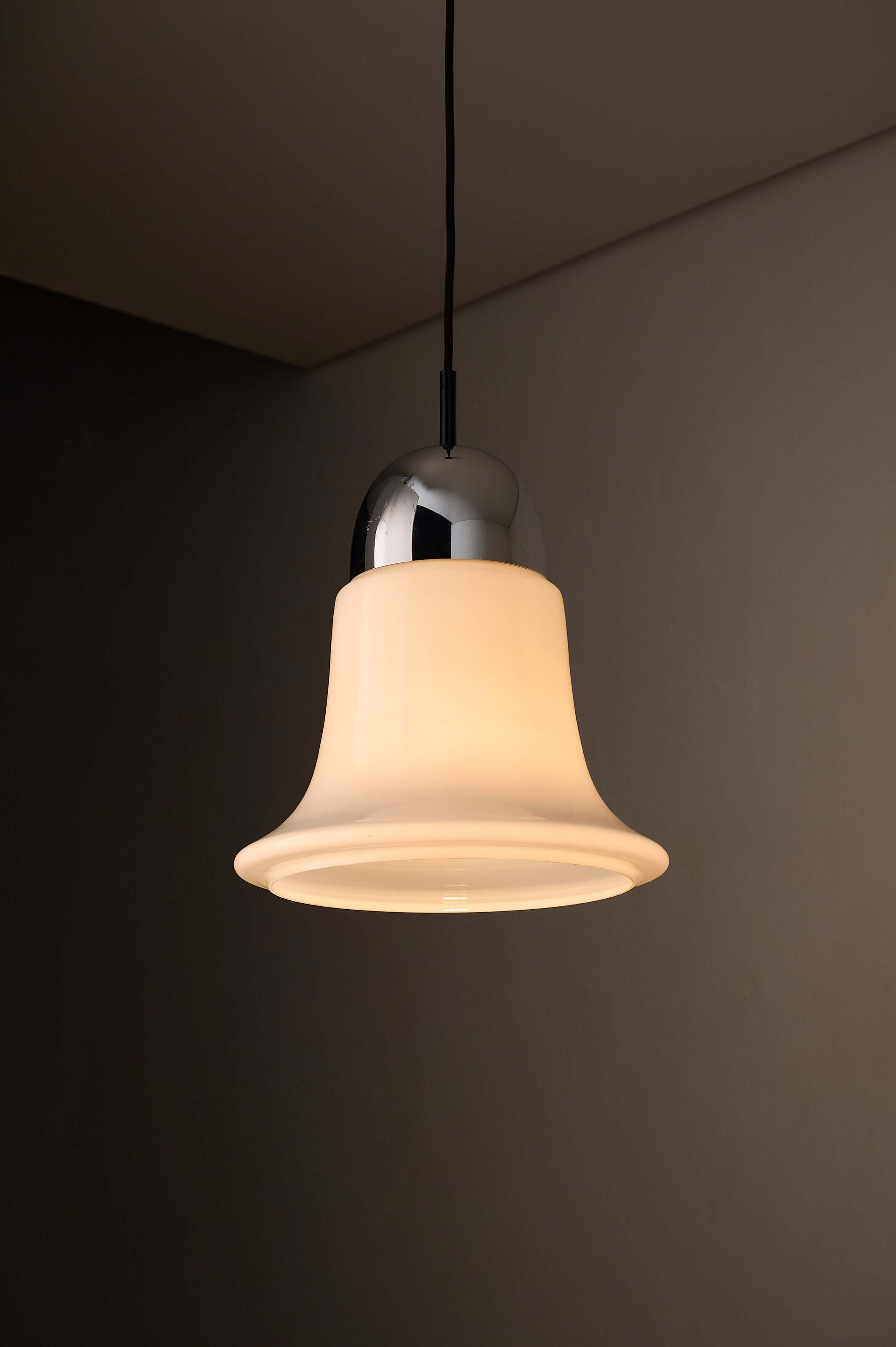 Mid-century opaline glass pendant light featuring a bell-shaped design and polished chrome cap.