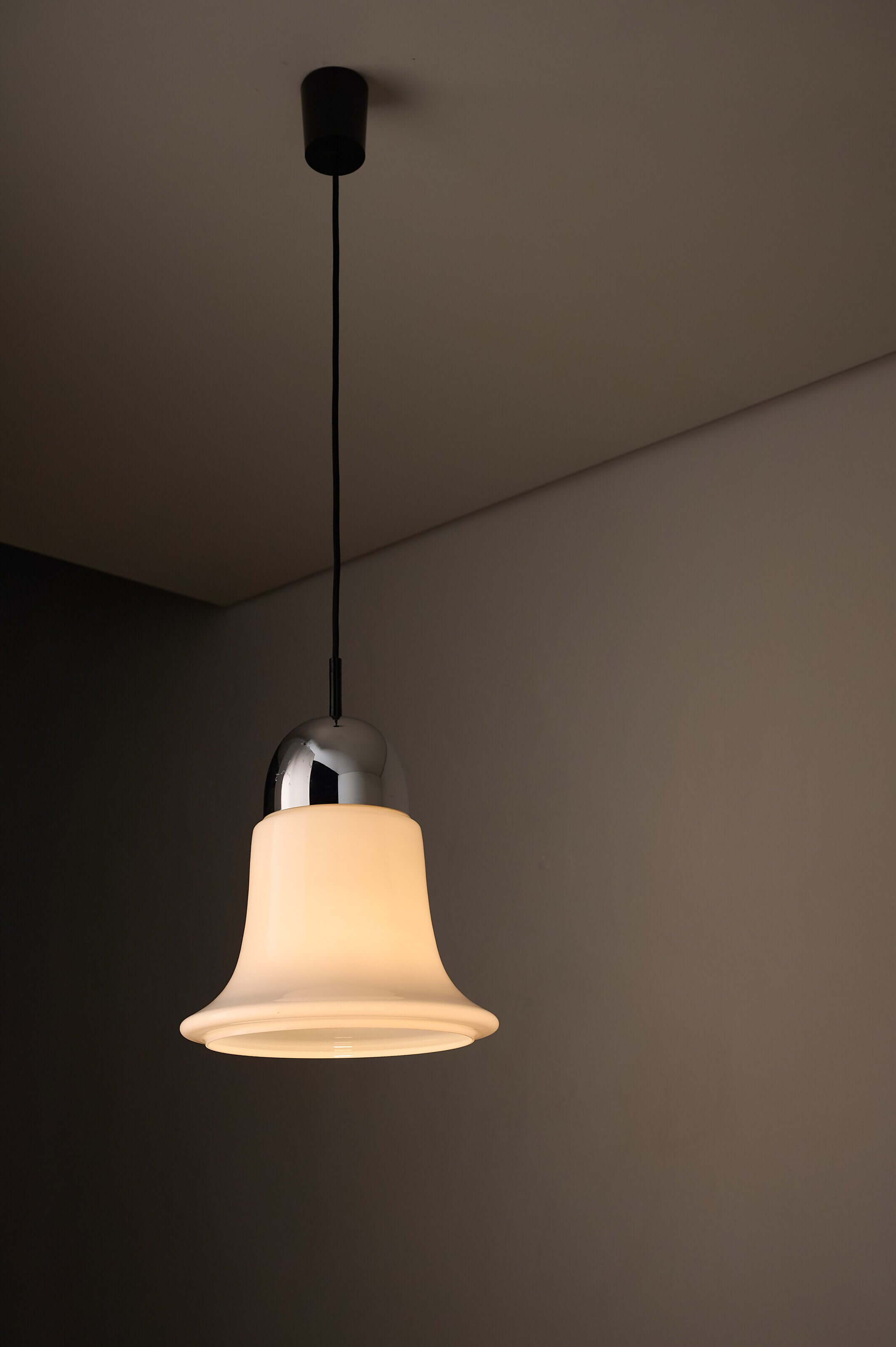 Mid-century opaline glass pendant light with chrome cap, featuring a bell-shaped design and soft glow.
