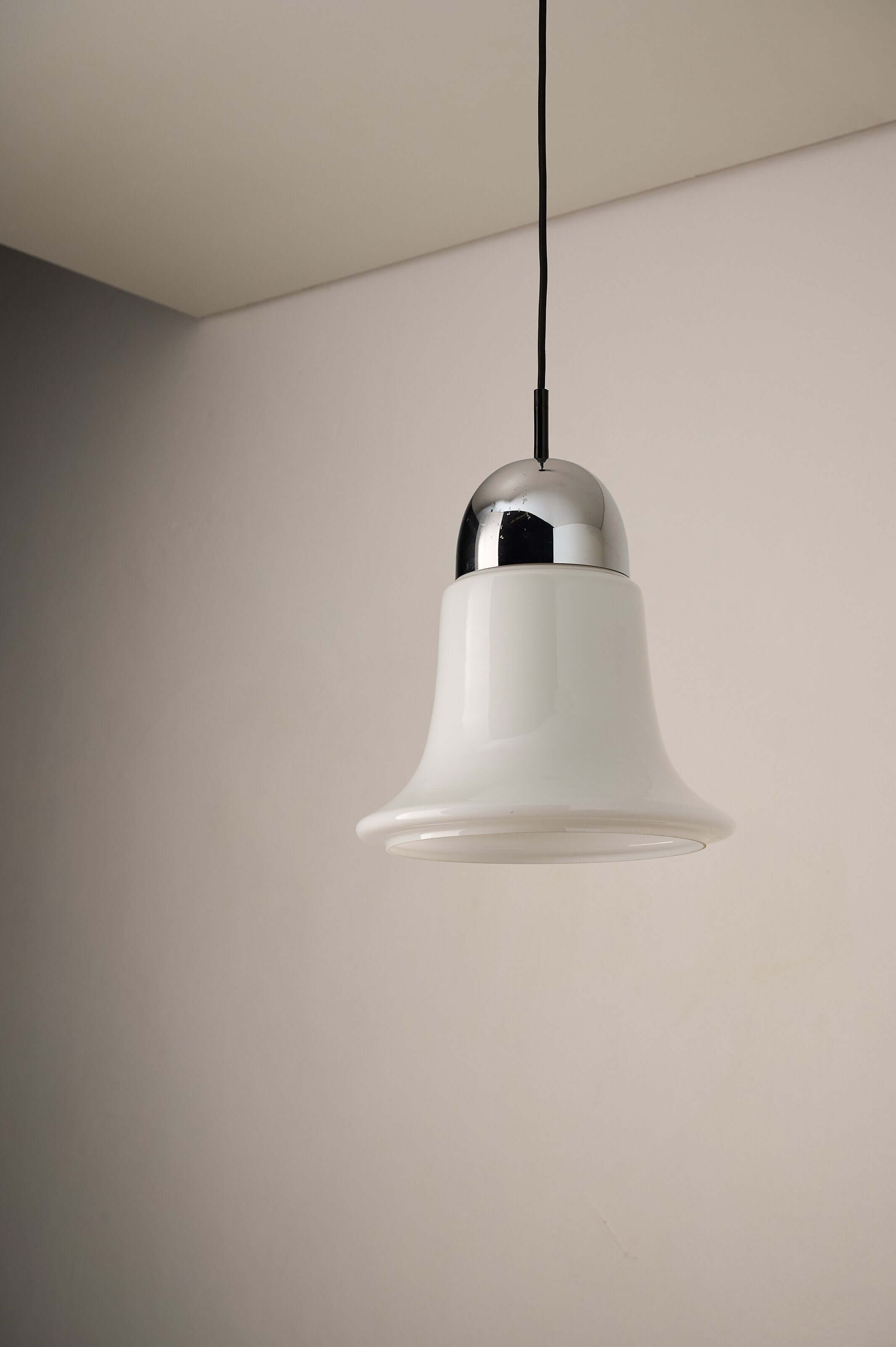 Mid-century opaline glass pendant light with chrome cap, bell-shaped design, softly diffusing light.