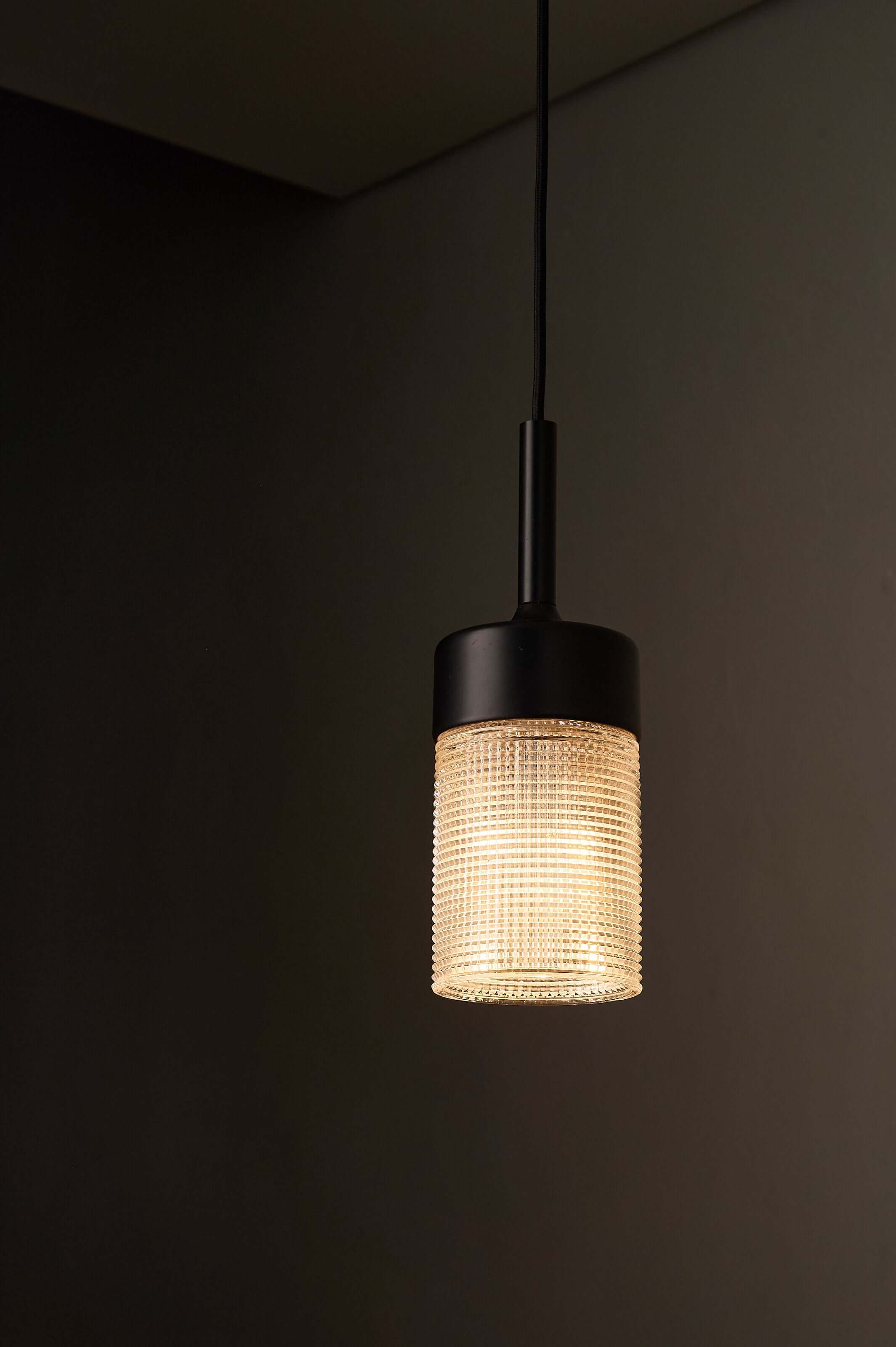 Black Model '7480' structured glass pendant light by Cosack, featuring a geometric grid pattern and warm illumination.