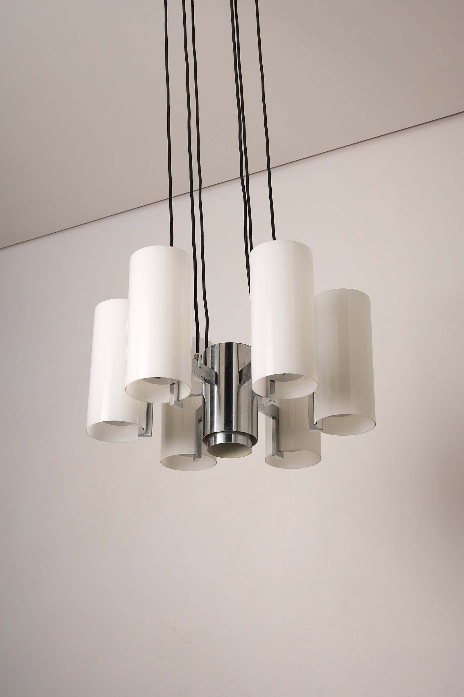 Space Age Chrome and Opaline Glass Chandelier with Six Cylindrical Shades hanging from the ceiling.