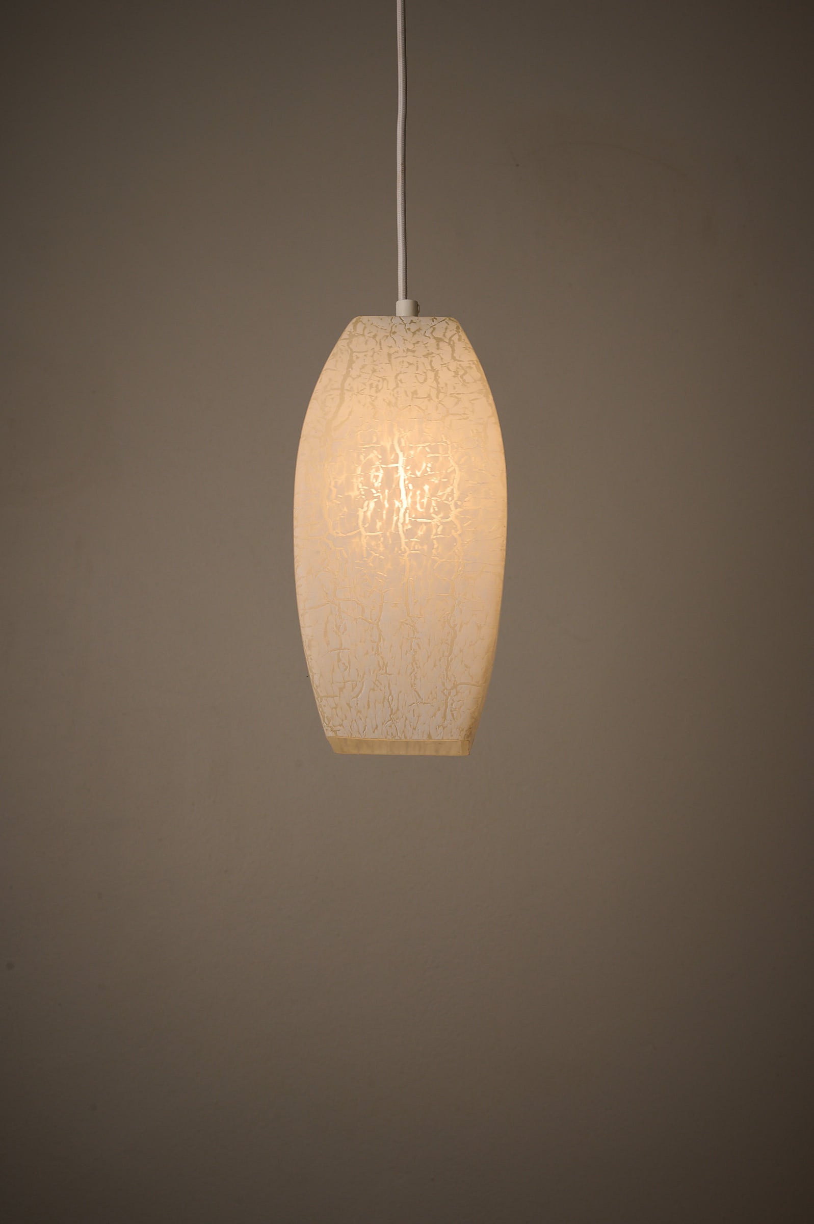 Trio of Ovoid Glass Pendants with Crackle Frosted Pattern, Europe, 1960s/1970s hanging lamp with soft ambient light.