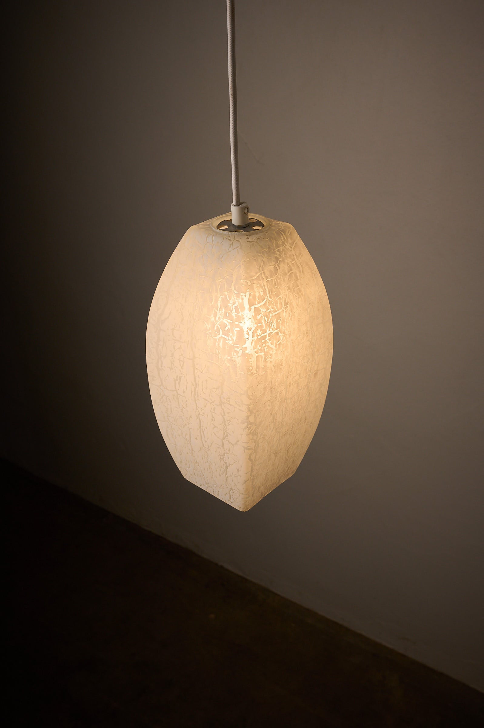 Trio of Ovoid Glass Pendants with Crackle Frosted Pattern, Europe, 1960s/1970s, elegantly illuminating with a soft ambient glow.