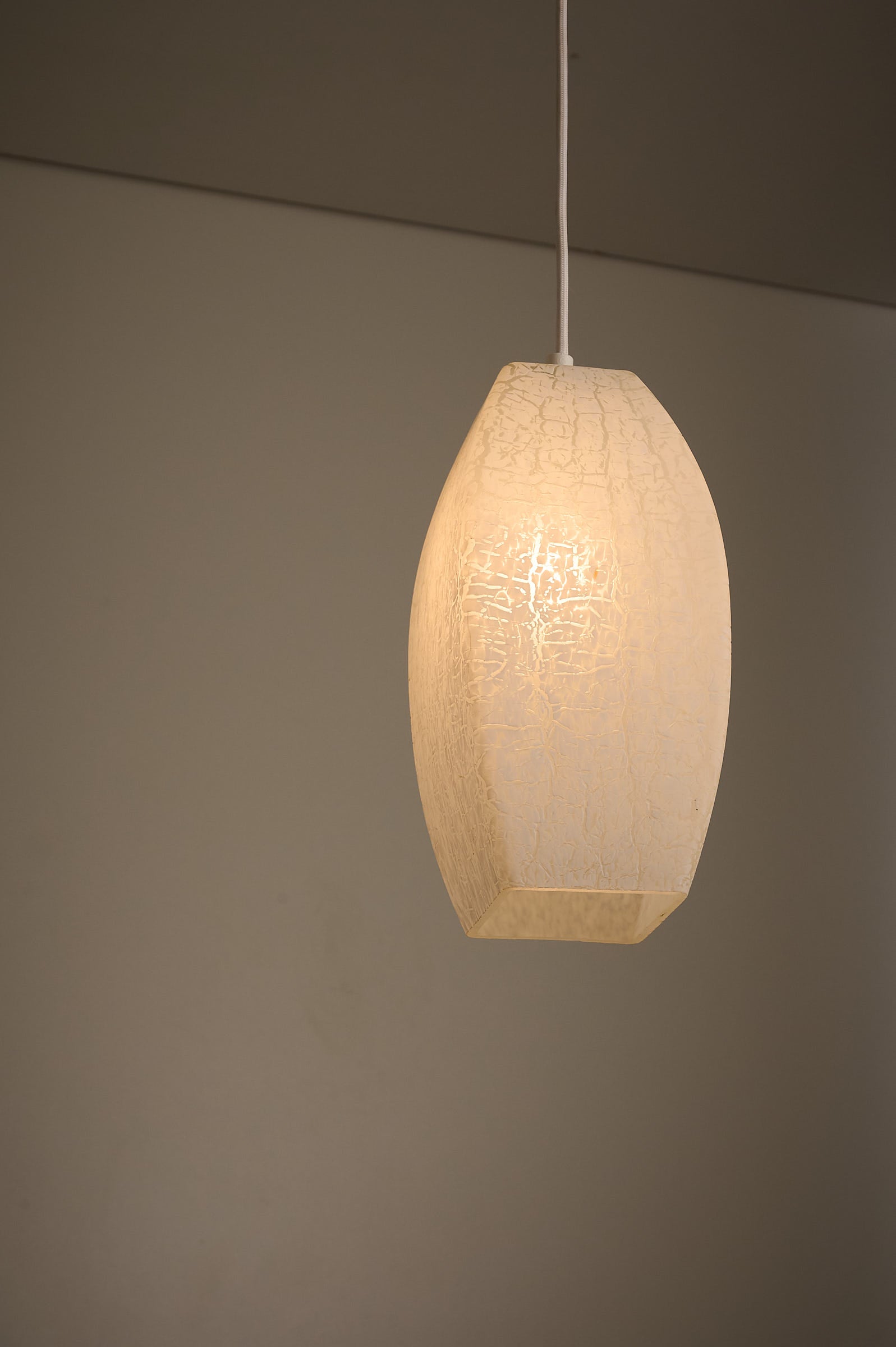 Trio of Ovoid Glass Pendants with Crackle Frosted Pattern, Europe, 1960s/1970s in warm ambient light.