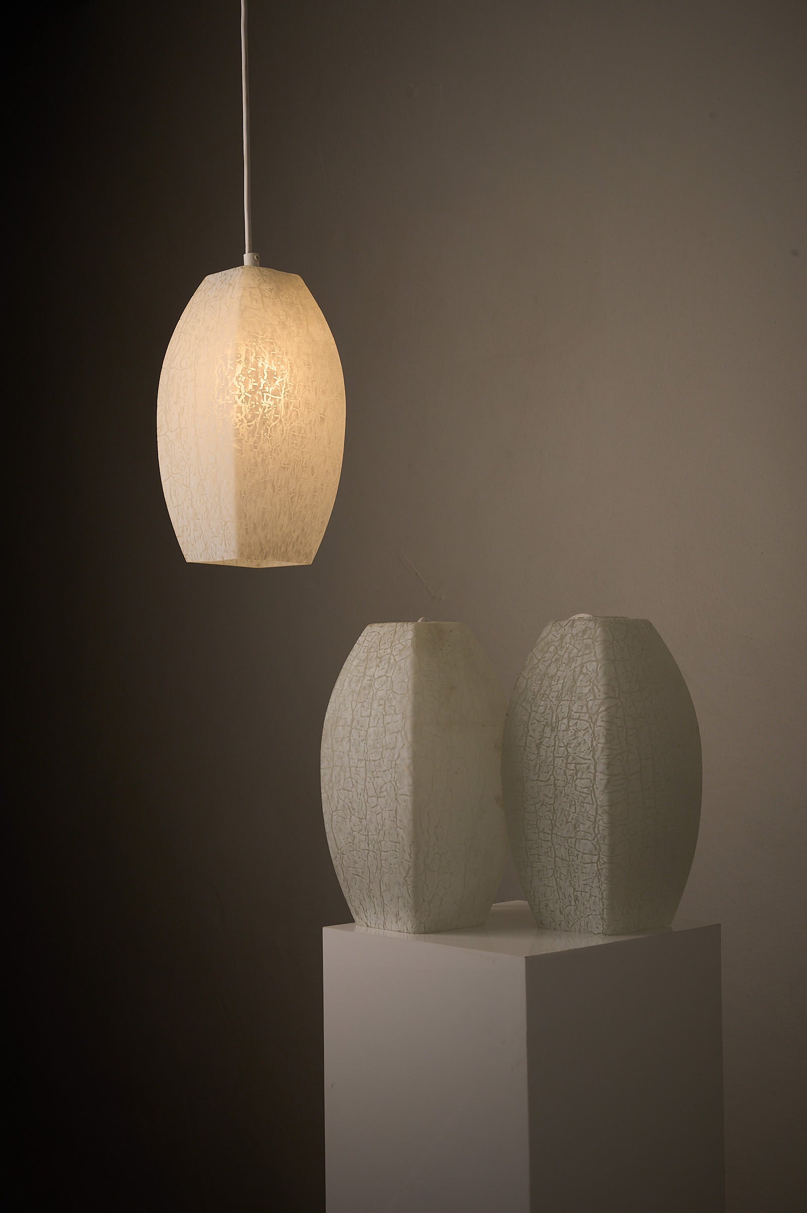 Trio of Ovoid Glass Pendants with Crackle Frosted Pattern, Europe, 1960s/1970s, illuminated with soft ambient glow.