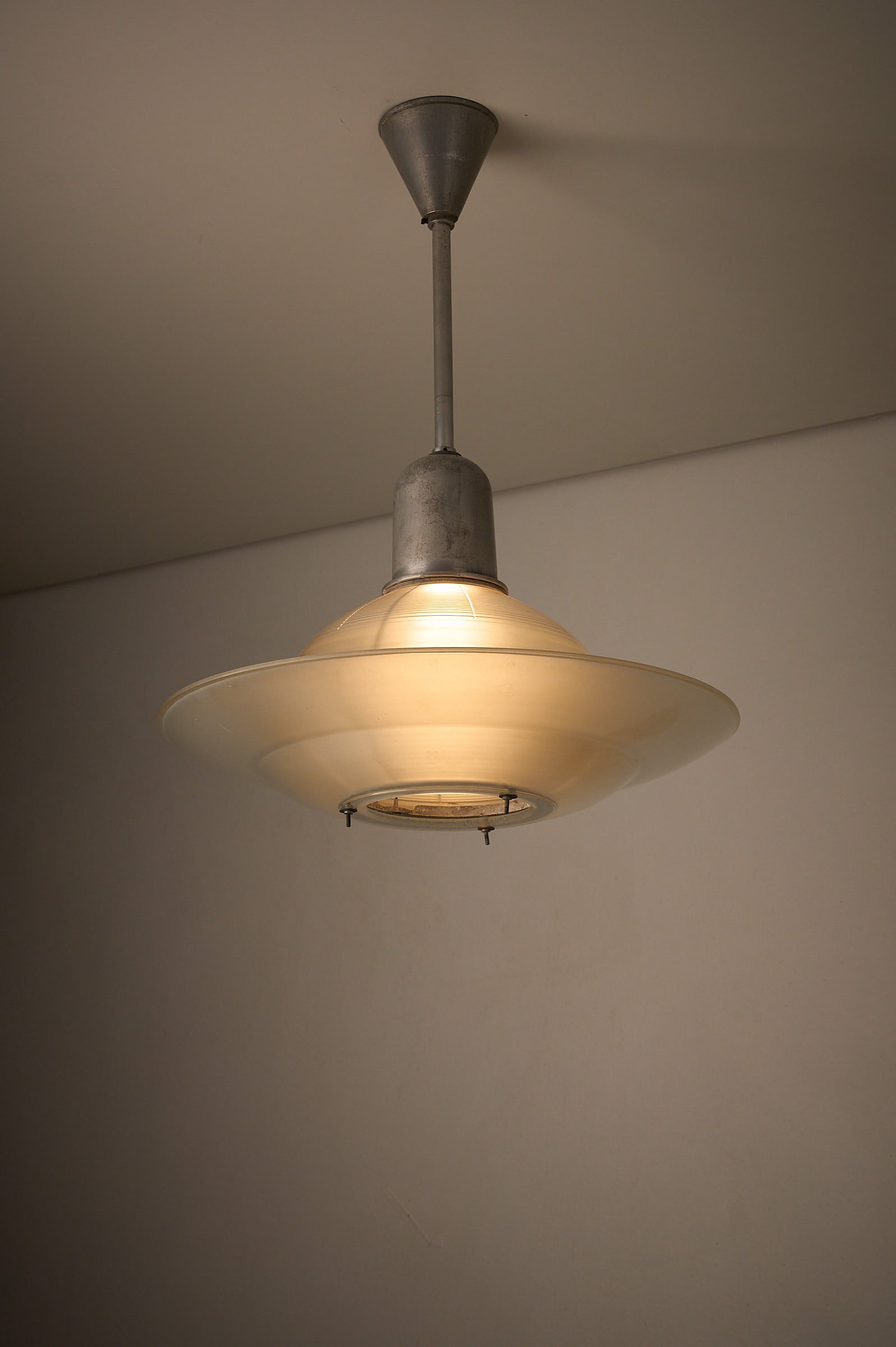 Art Deco Industrial Pendant, 1930s hanging lamp with glass shade and metal accents.