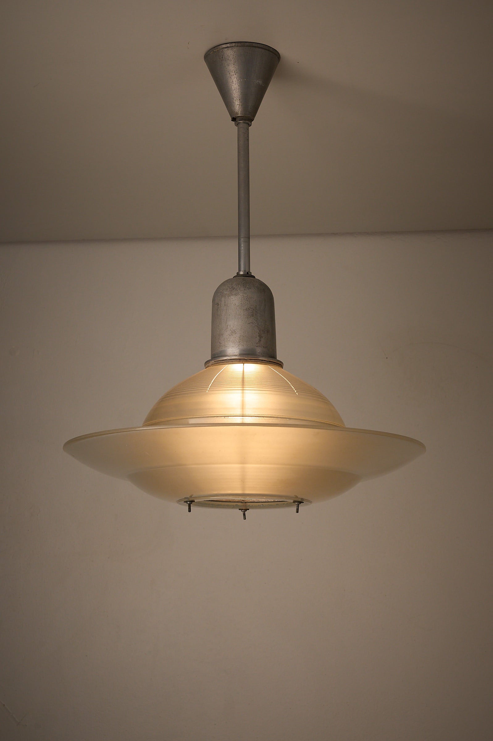 Art Deco Industrial Pendant, 1930s featuring a glass shade and adjustable screws for light diffusion.