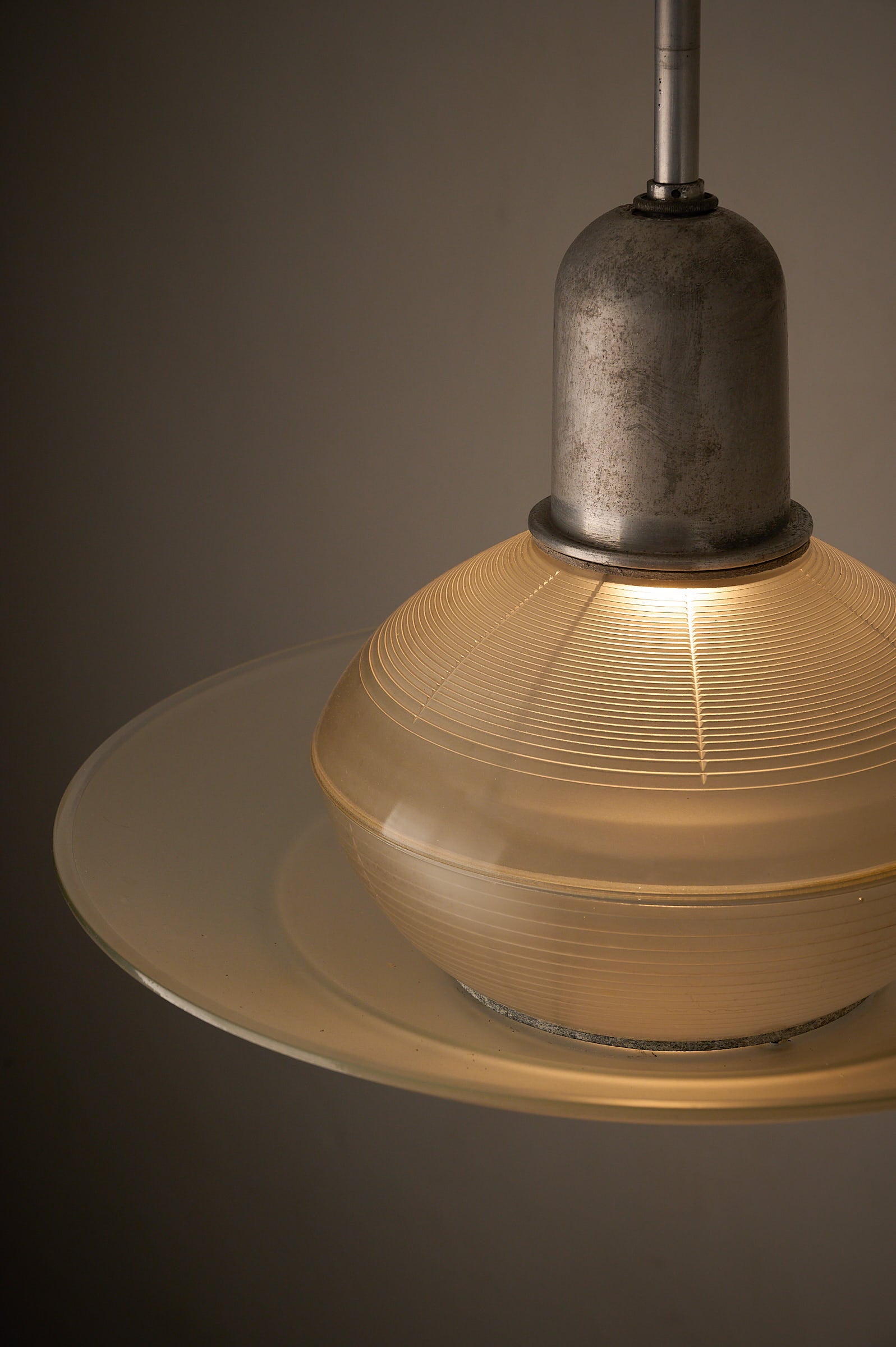 Art Deco Industrial Pendant, 1930s featuring a glass shade with ribbed design and adjustable screws for diffusion.