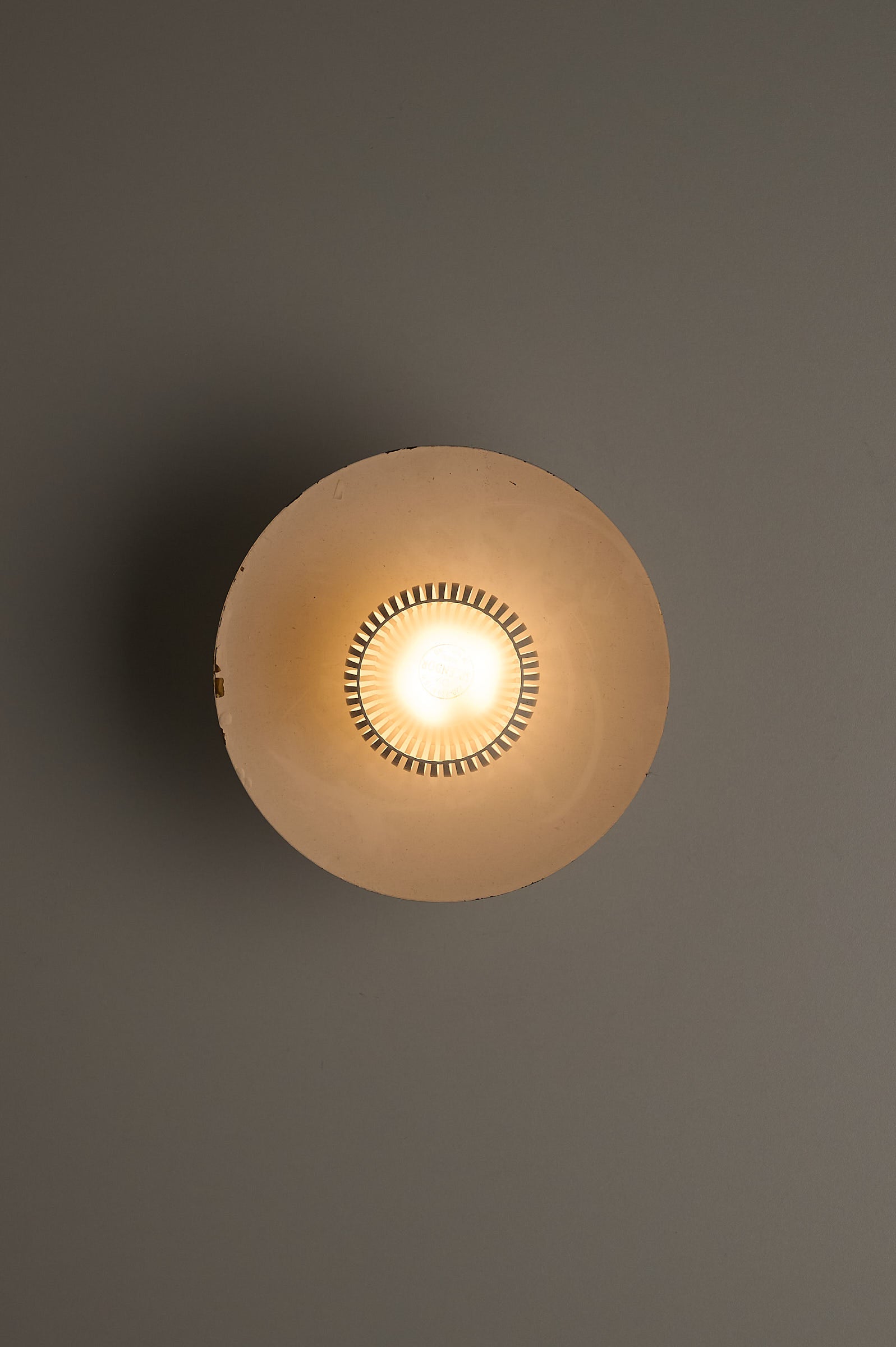 Mid-Century Flush Mount Ceiling Lamp with White Slatted Diffuser top view highlighting the slatted design and warm light.
