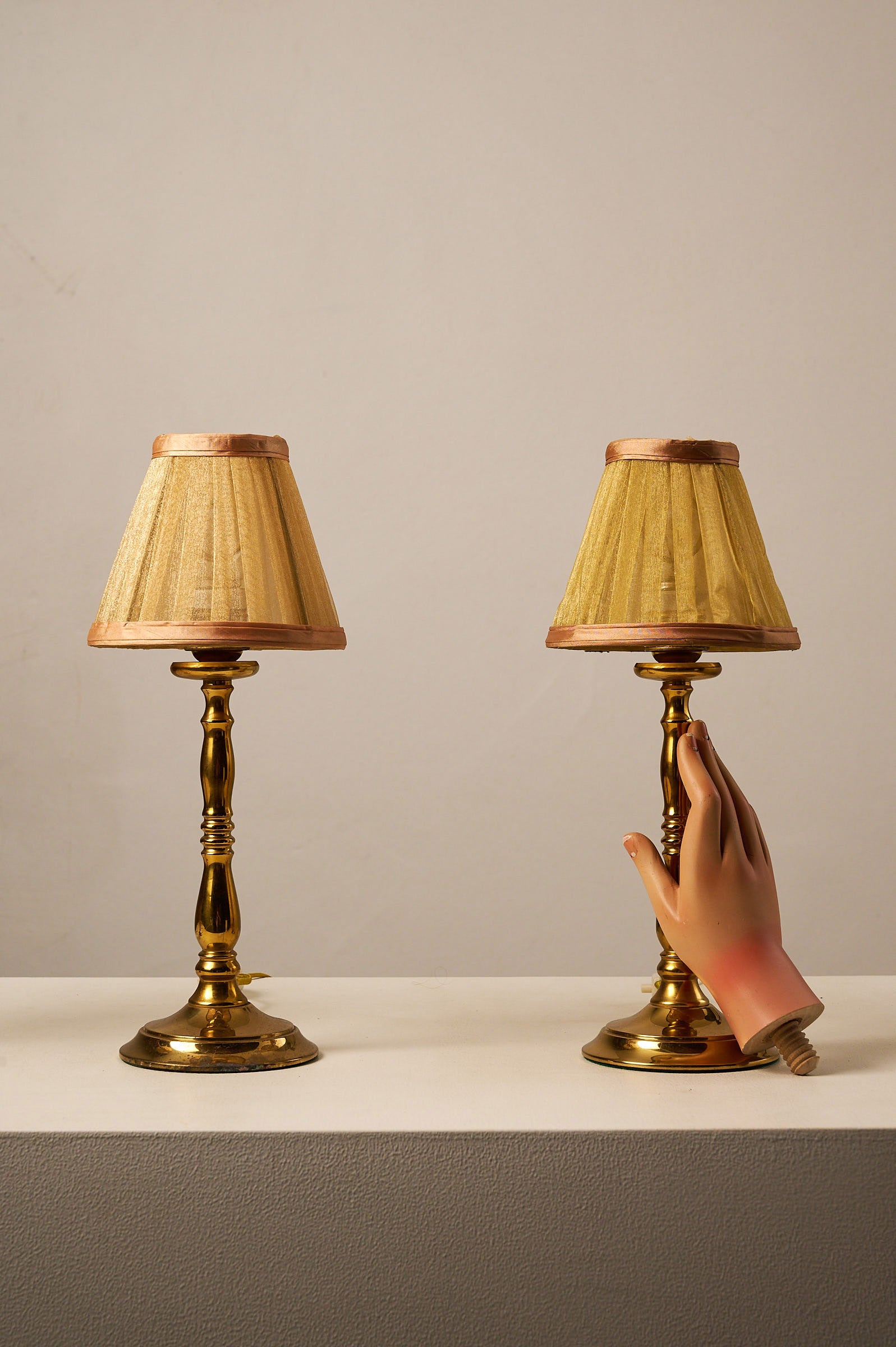Hollywood Regency Brass Table Lamps, Europe, 1970s with pleated shades on a display table.