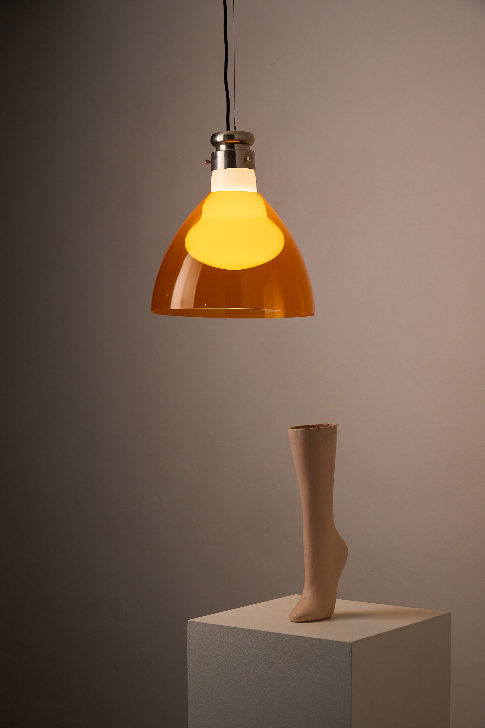 Space Age Blown Glass Pendant Lamp by Vistosi, Italy, 1970s hanging above a sculptural leg display.