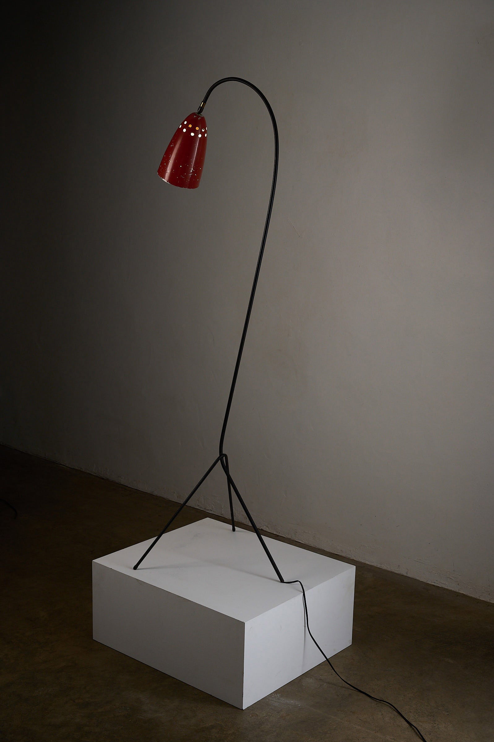 'Grasshopper' Floor Lamp, The Netherlands, 1950s. Slender black tripod with vibrant red shade on display.