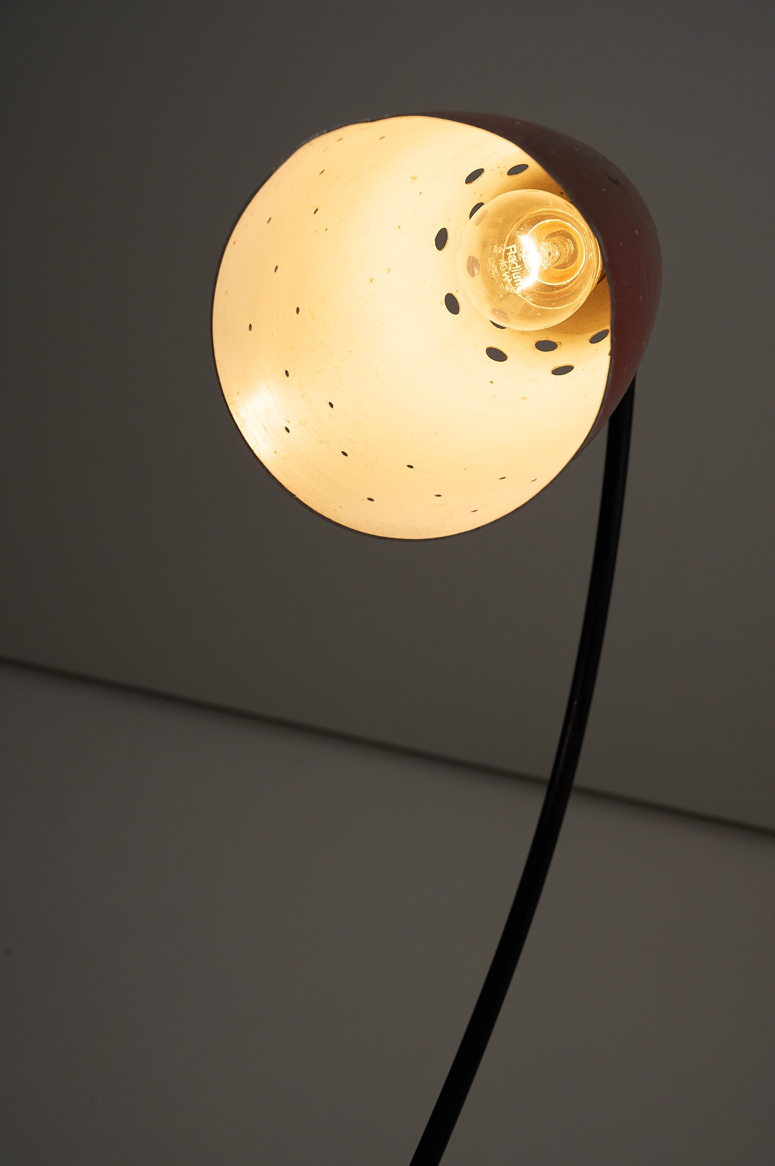 'Grasshopper' Floor Lamp, The Netherlands, 1950s with a sleek design and vibrant red shade illuminating a cozy space.