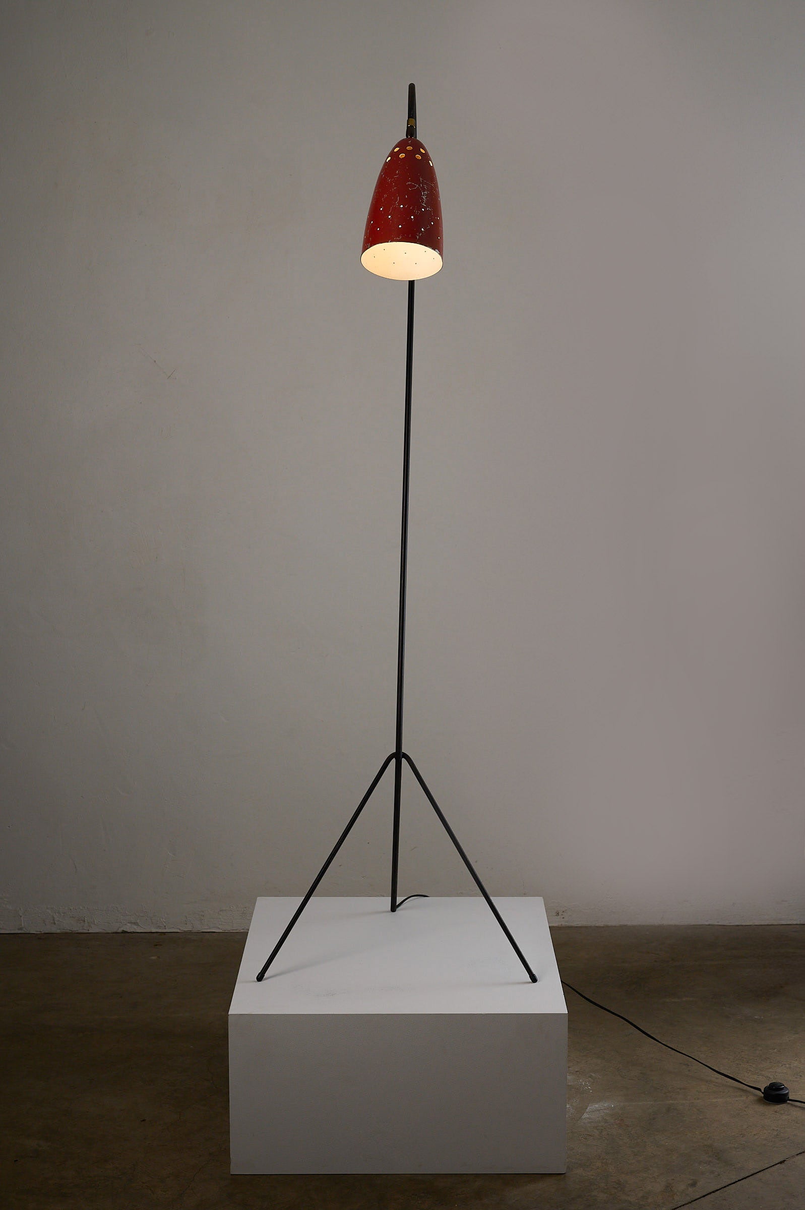 'Grasshopper' Floor Lamp, The Netherlands, 1950s on display with black tripod and red shade.