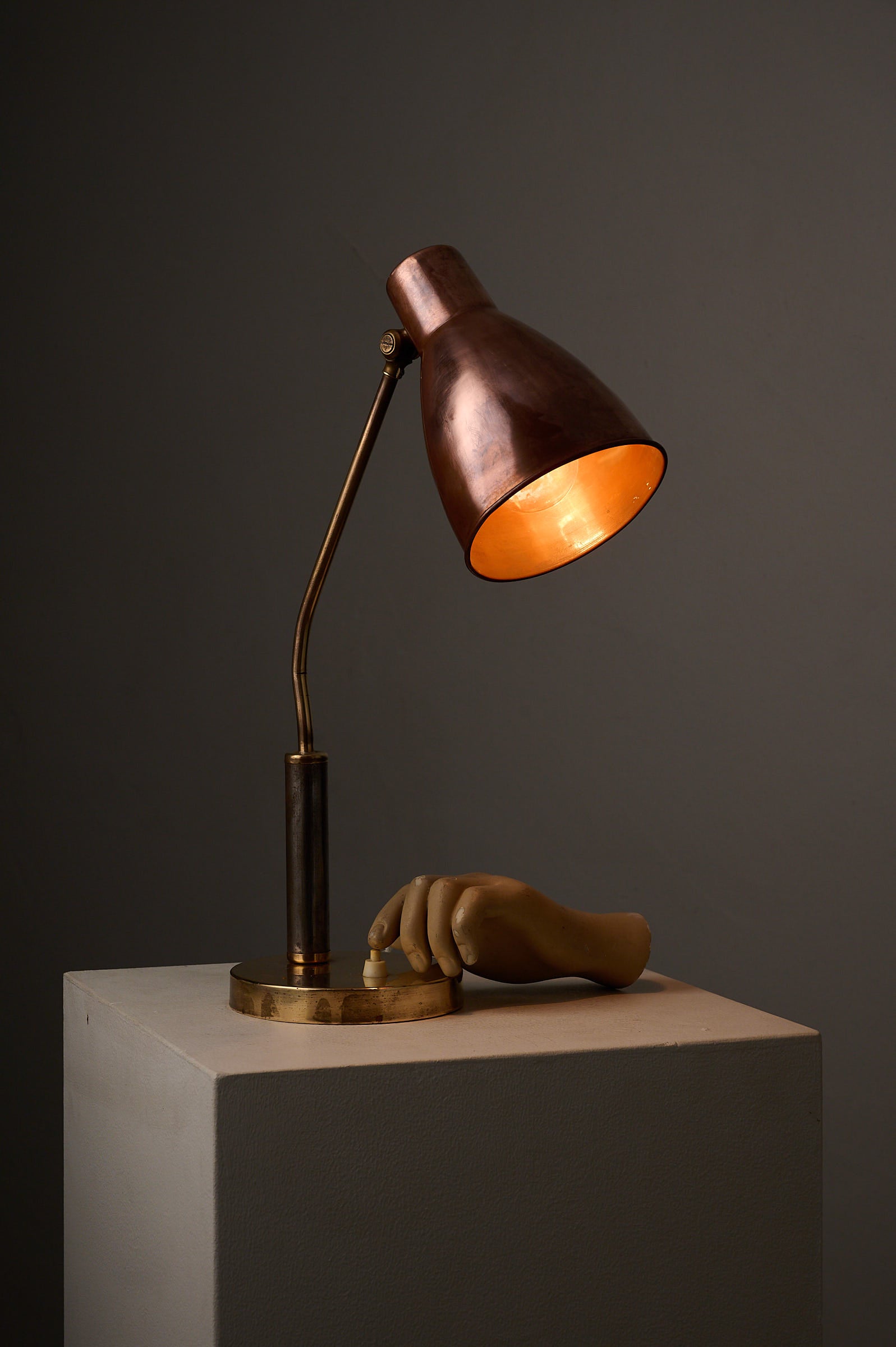 Mid-Century Modern Copper & Brass Desk Lamp, Europe, 1950s on display with a unique hand sculpture.