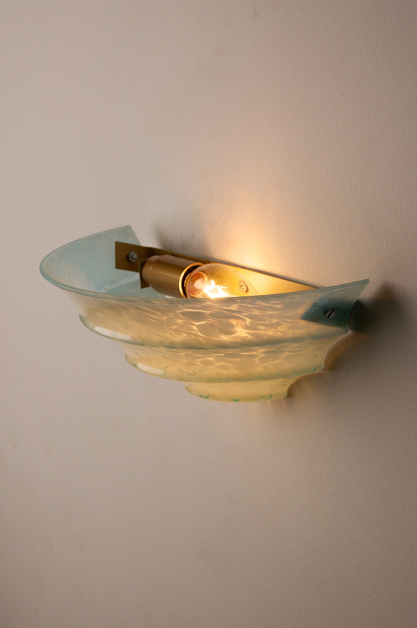 1940s Mid-Century Blue Marbled Glass Shell Wall Sconce illuminating a wall with a shell-shaped glass shade.