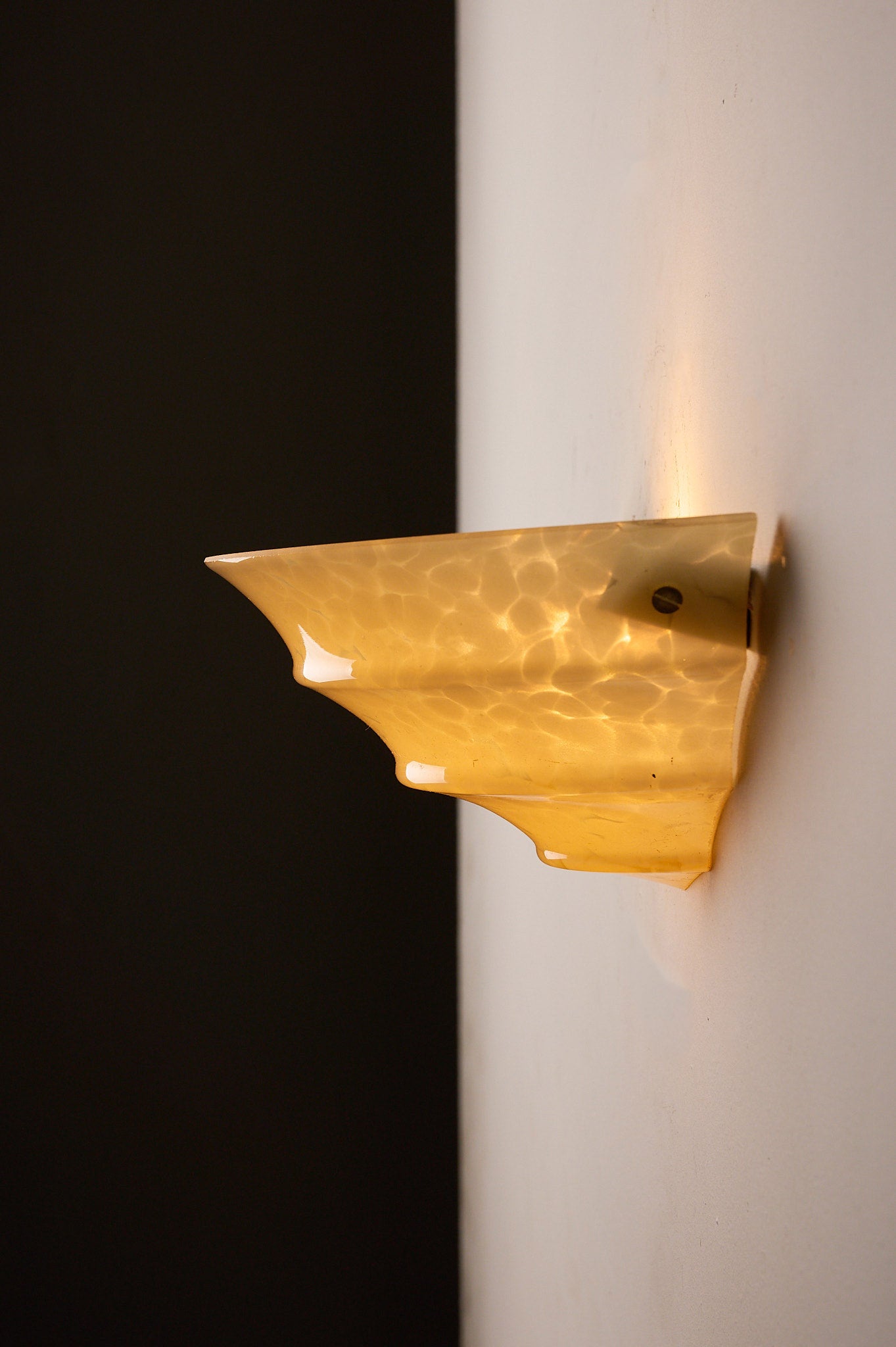 1970s Mid-Century Yellow Marbled Glass Shell Wall Sconce mounted on a wall, showcasing its elegant design and warm light.