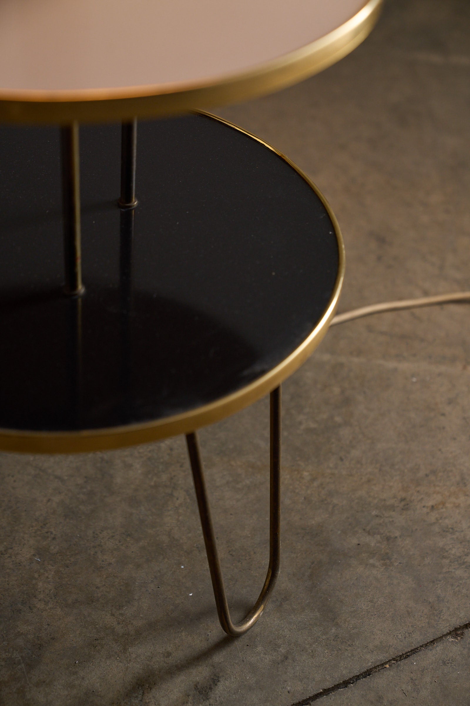 Brass Hairpin Table Floor Lamp with Venetian Shade two-tiered side table structure with brass legs and glossy surfaces.
