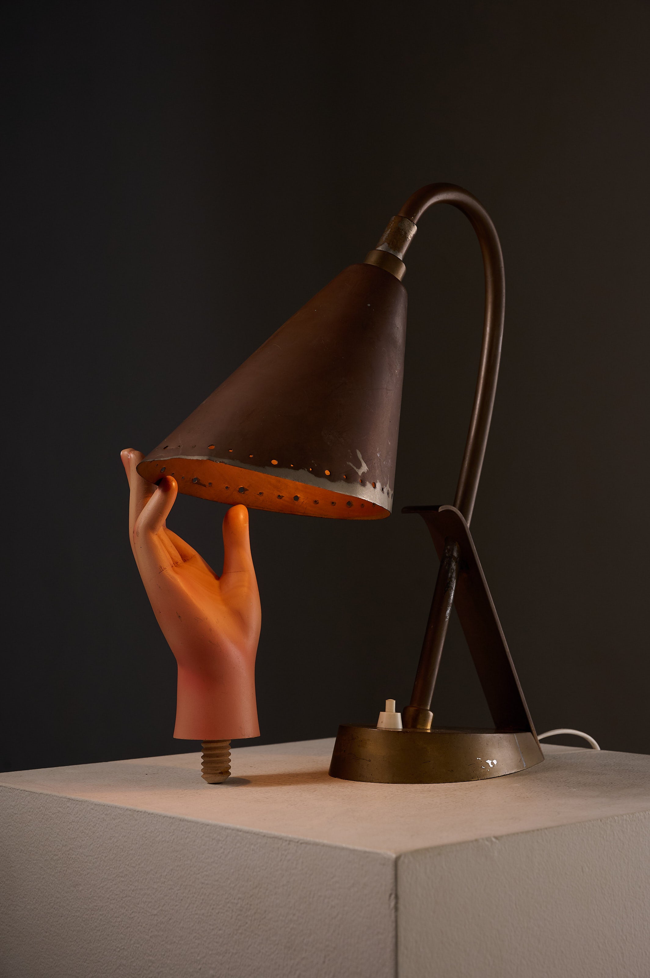 Copper & Brass Table Lamp, France with asymmetrical copper shade and hand-shaped base in a dark setting.