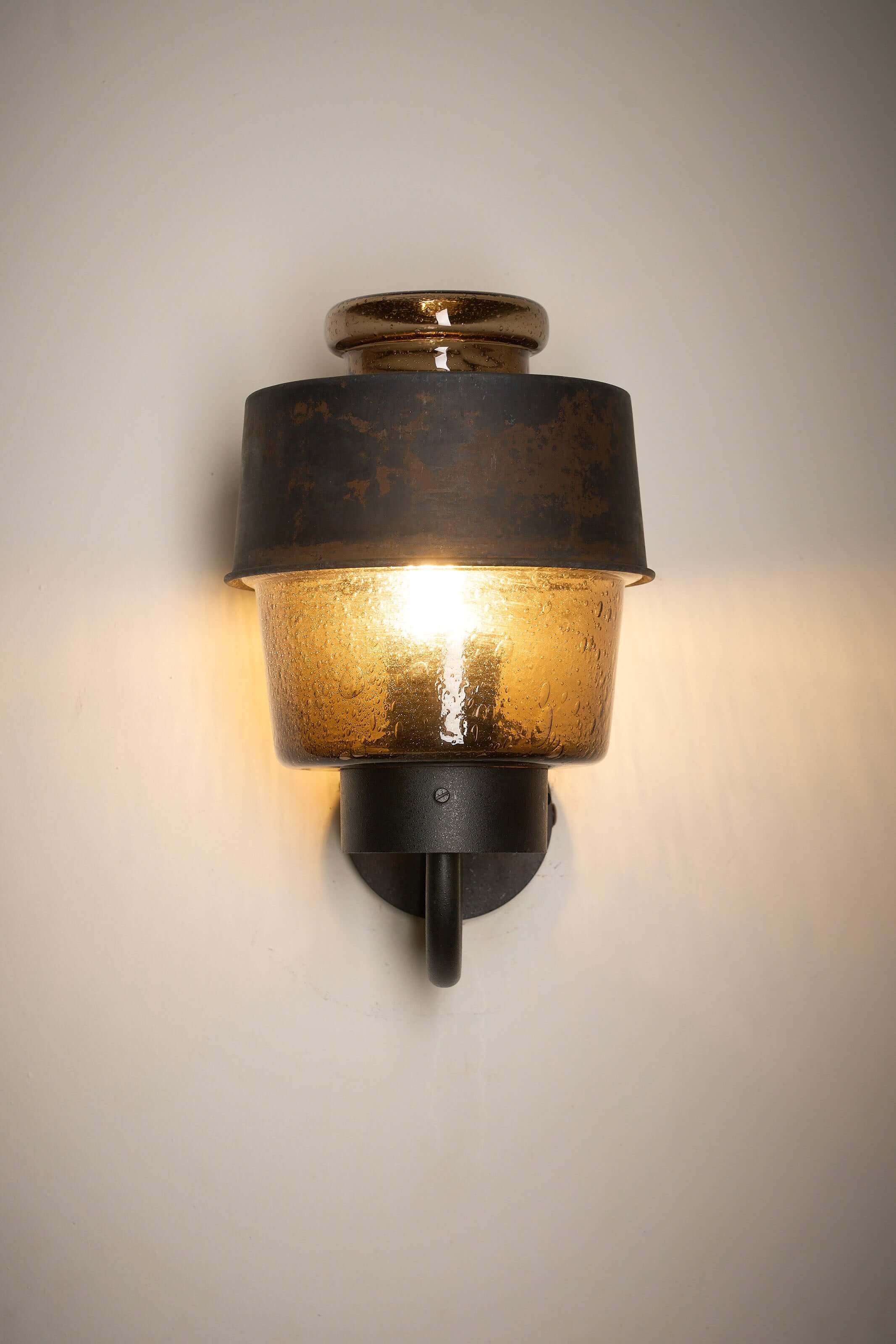 Outdoor Lantern with Amber Bubble Glass by Boom Bega mounted on a wall, illuminating with a warm light.