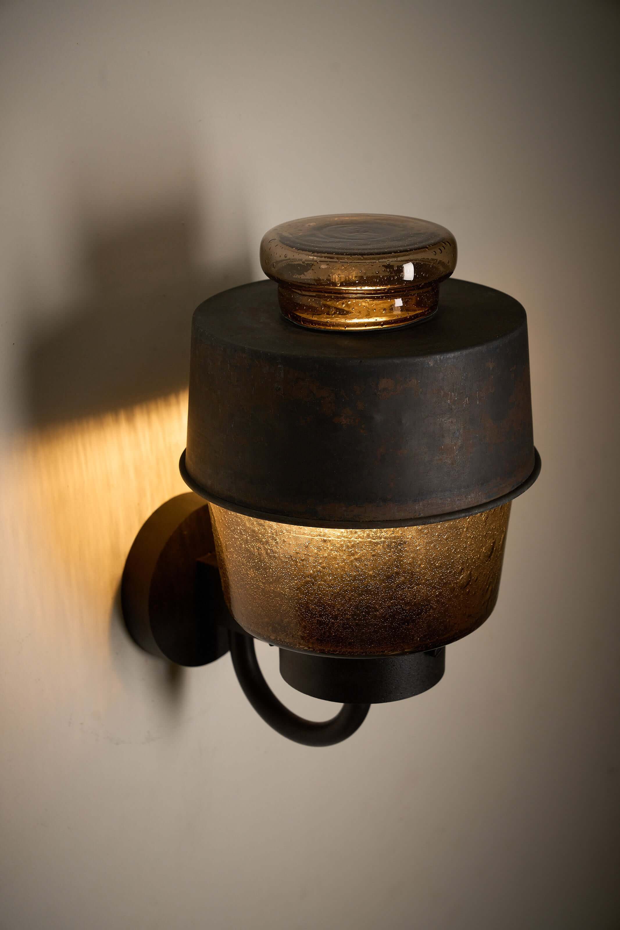 Outdoor Lantern with Amber Bubble Glass by Boom Bega mounted on wall, showcasing industrial design and warm light.