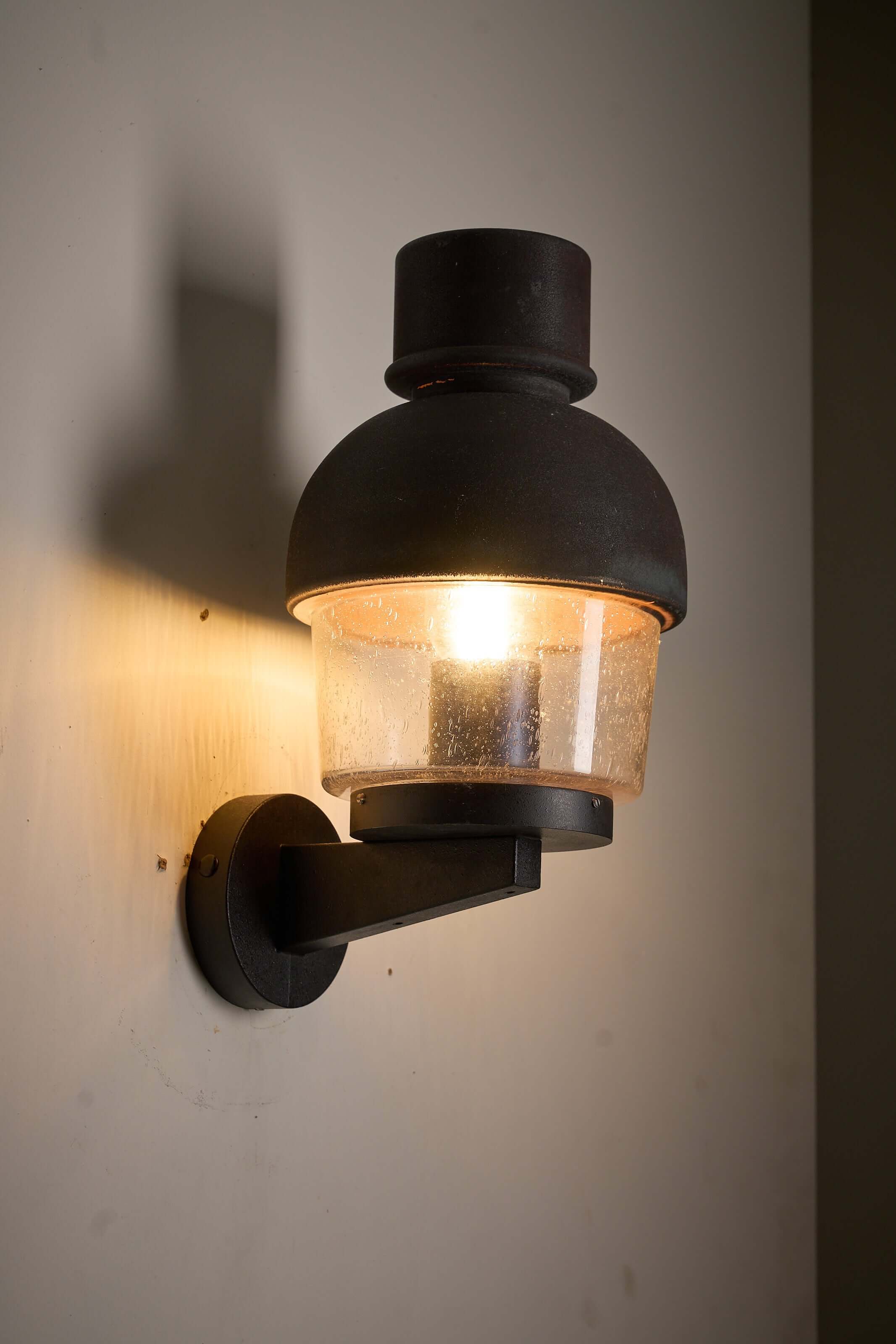 'Boom' Wall Lamp with Fused Copper Alloy on Glass illuminating a wall.