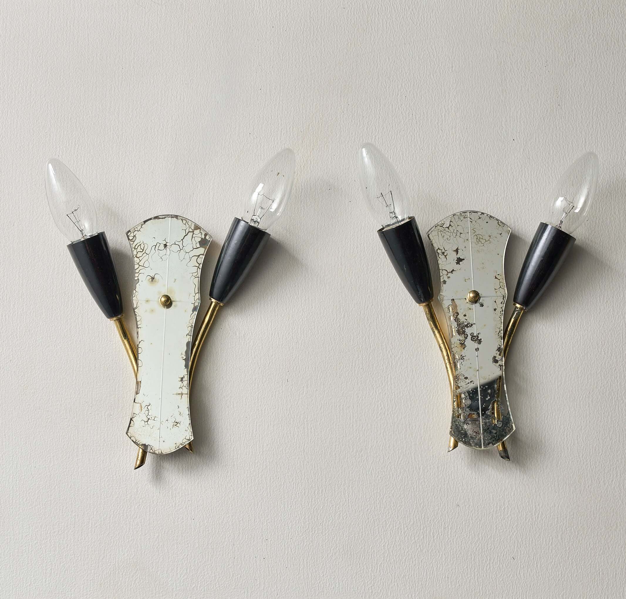 Brass and Mirrored Glass Wall Lamp, 1950s featuring asymmetrical design with curved brass arms and black cone lampholders.