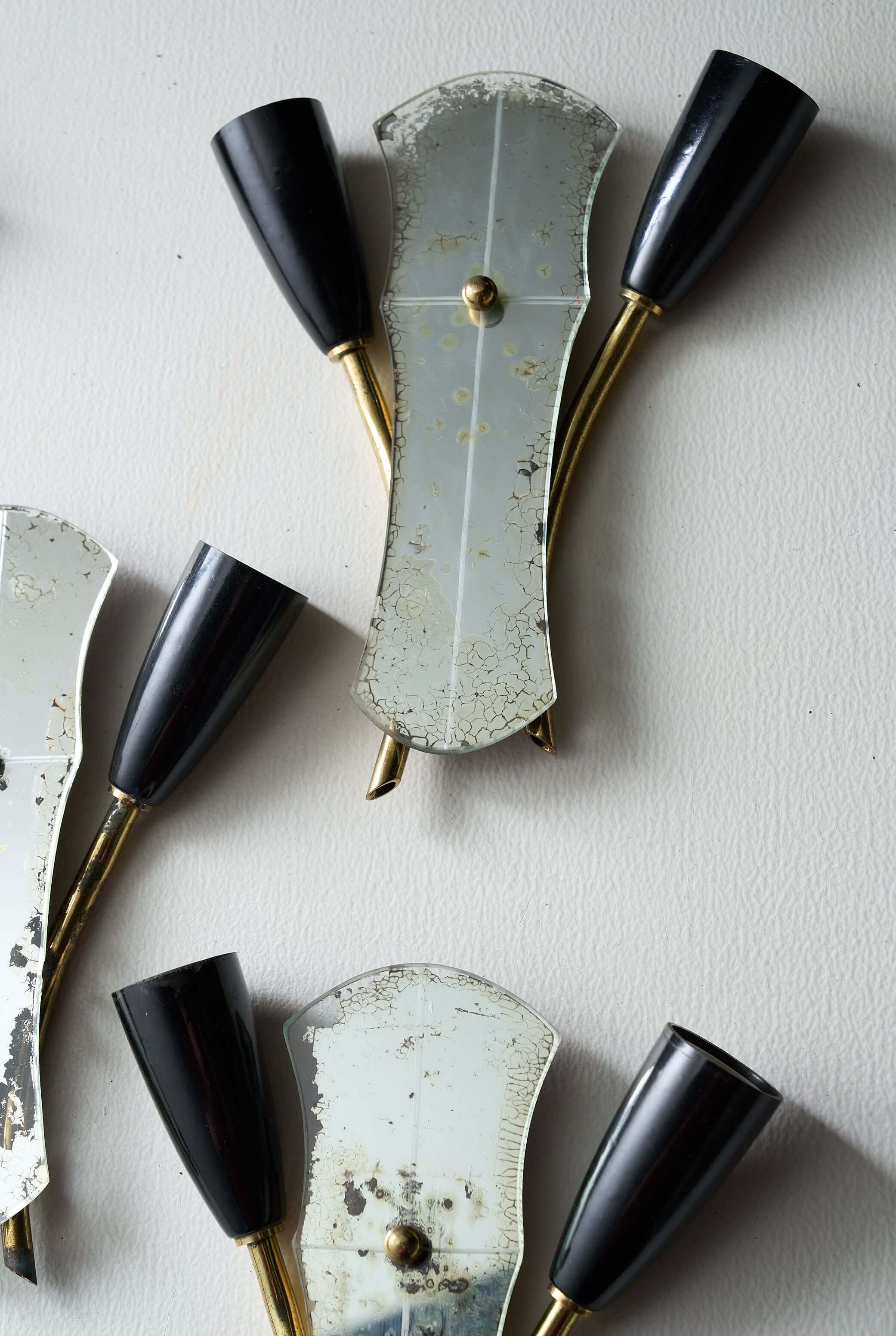 Brass and Mirrored Glass Wall Lamp, 1950s with a unique asymmetrical design and black cone-shaped lampholders.