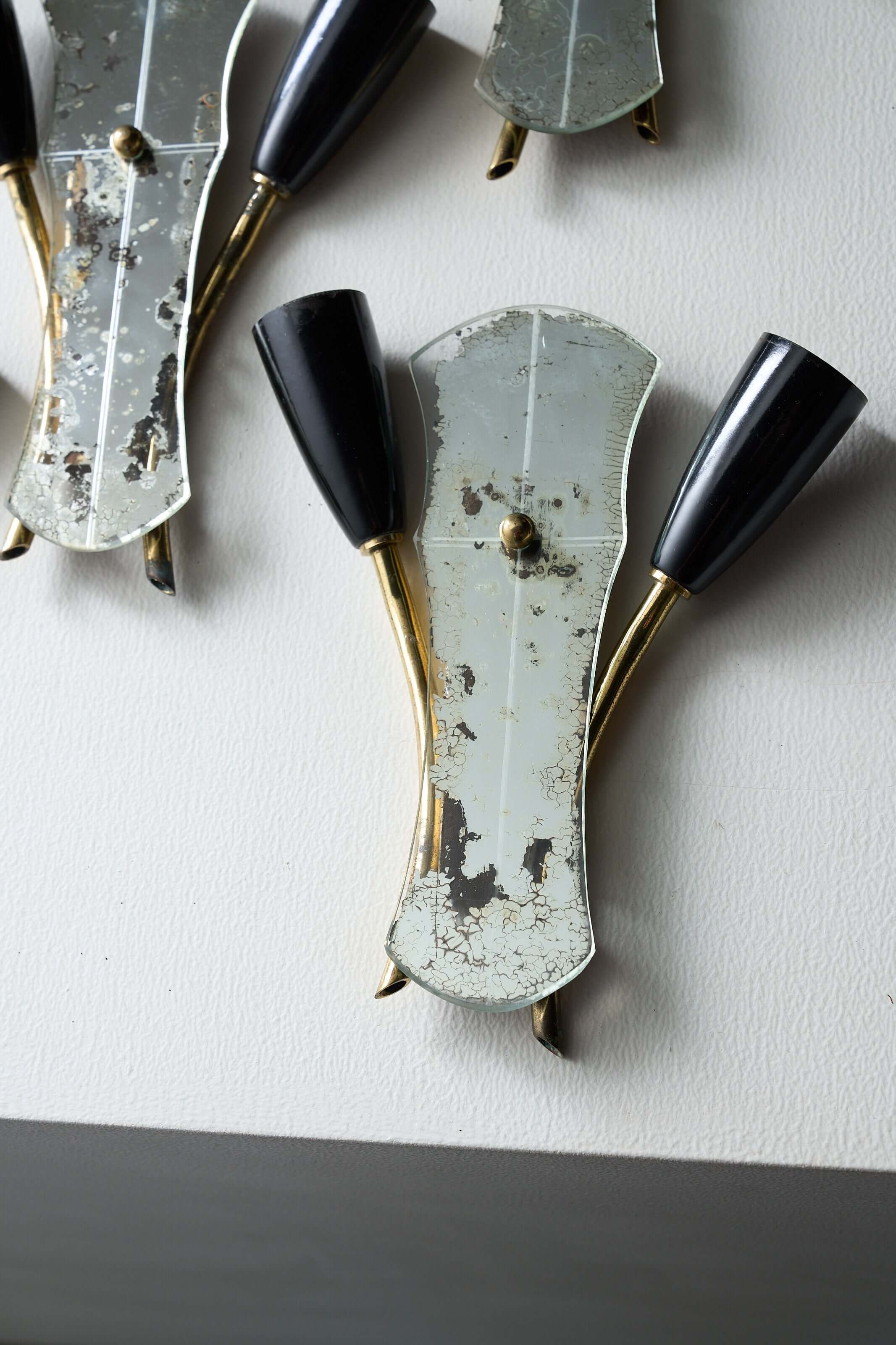 Brass and Mirrored Glass Wall Lamp, 1950s featuring asymmetrical design with black cone lampholders.