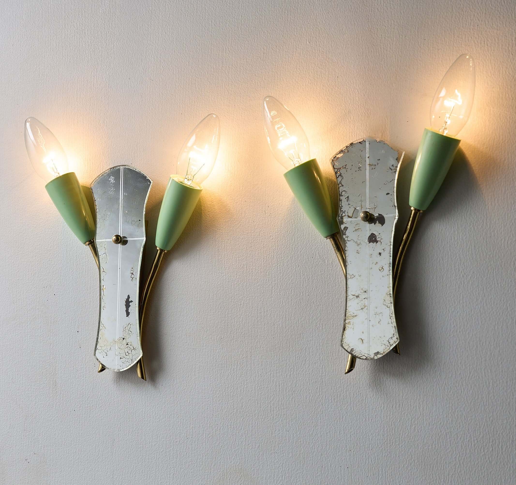 Brass and Mirrored Glass Wall Lamp, 1950s featuring pale green lampholders and a shaped mirror.