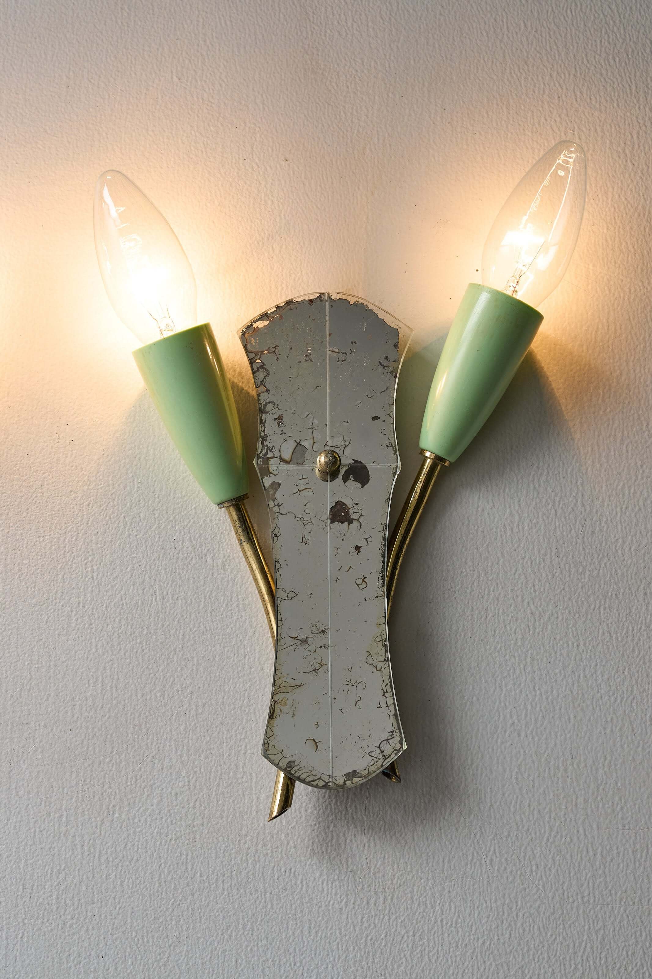 Brass and Mirrored Glass Wall Lamp, 1950s featuring two cone-shaped lampholders and a shaped mirror.
